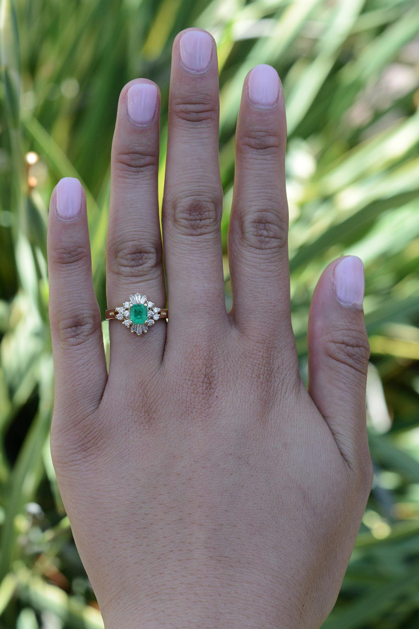 This vintage emerald cocktail ring is a beautiful and affordable statement piece for any jewelry collection. Crafted from 14 karat yellow gold and featuring over 3/4 carats total of sparkling diamonds. Centering on a sustainable 0.60 carat emerald