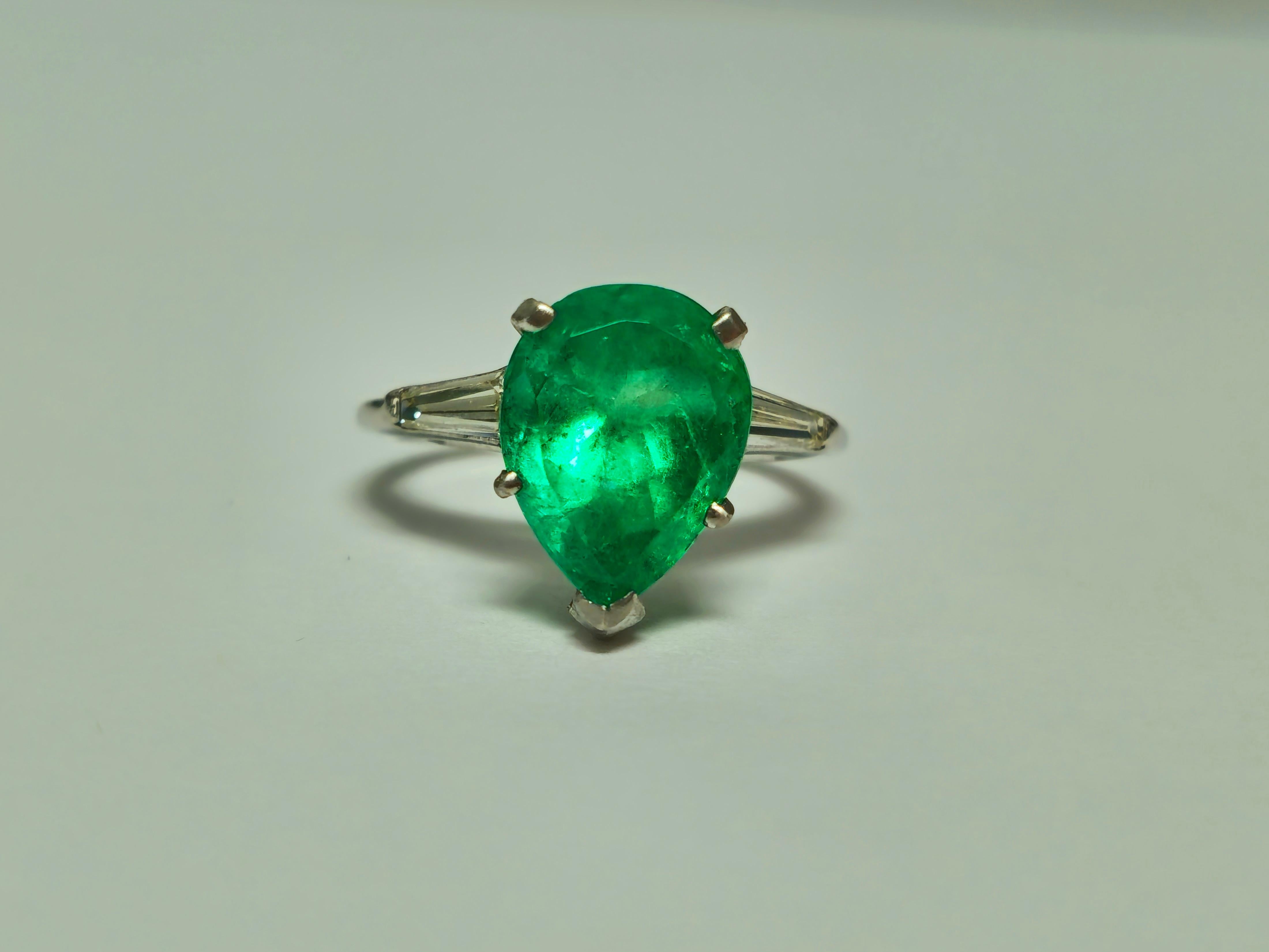 Immerse yourself in timeless luxury with our exquisite Unisex Diamond, Emerald, and Platinum Ring. Crafted from solid platinum, this one-of-a-kind vintage jewelry piece features a stunning 4.50 carat pear-shaped Colombian emerald set in prongs,