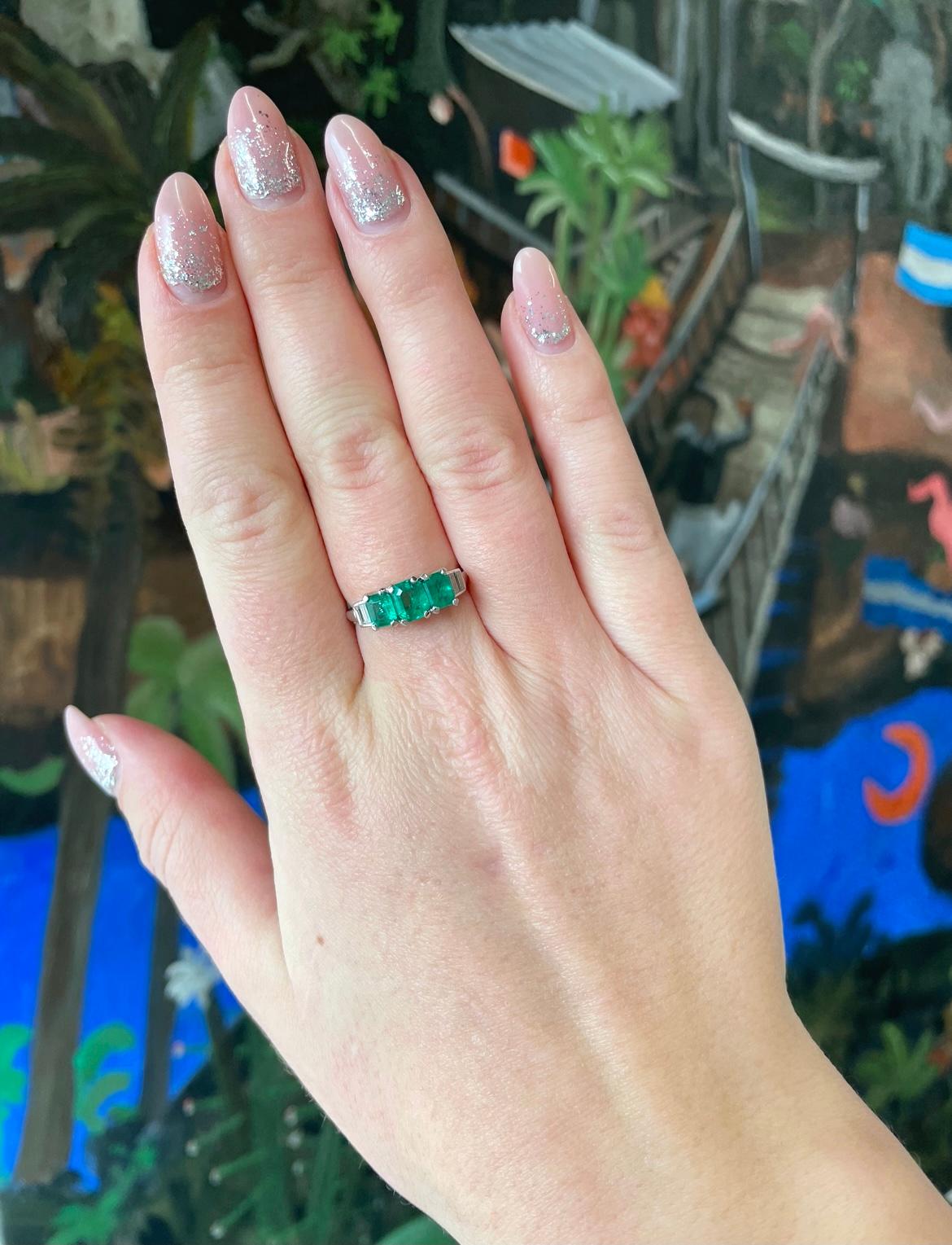 The vivid green color of these emeralds, just momentarily, brings peace of mind. Experience warmth and joy every time you look at this Vintage Emerald Diamond Platinum Ring. The emerald cut emeralds are approximately 0.70 carat, 0.45 carat, 0.50