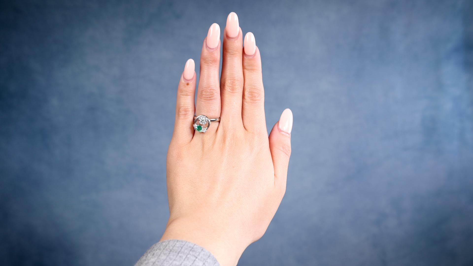 Une bague Vintage Emerald Diamond Platinum Spinner Ring. Elle contient une émeraude de 0,30 carat. Accentué par sept diamants ronds de taille brillant d'un poids total de 0,35 carat, de couleur G-H et de pureté VS. Fabriqué en platine, la marque de