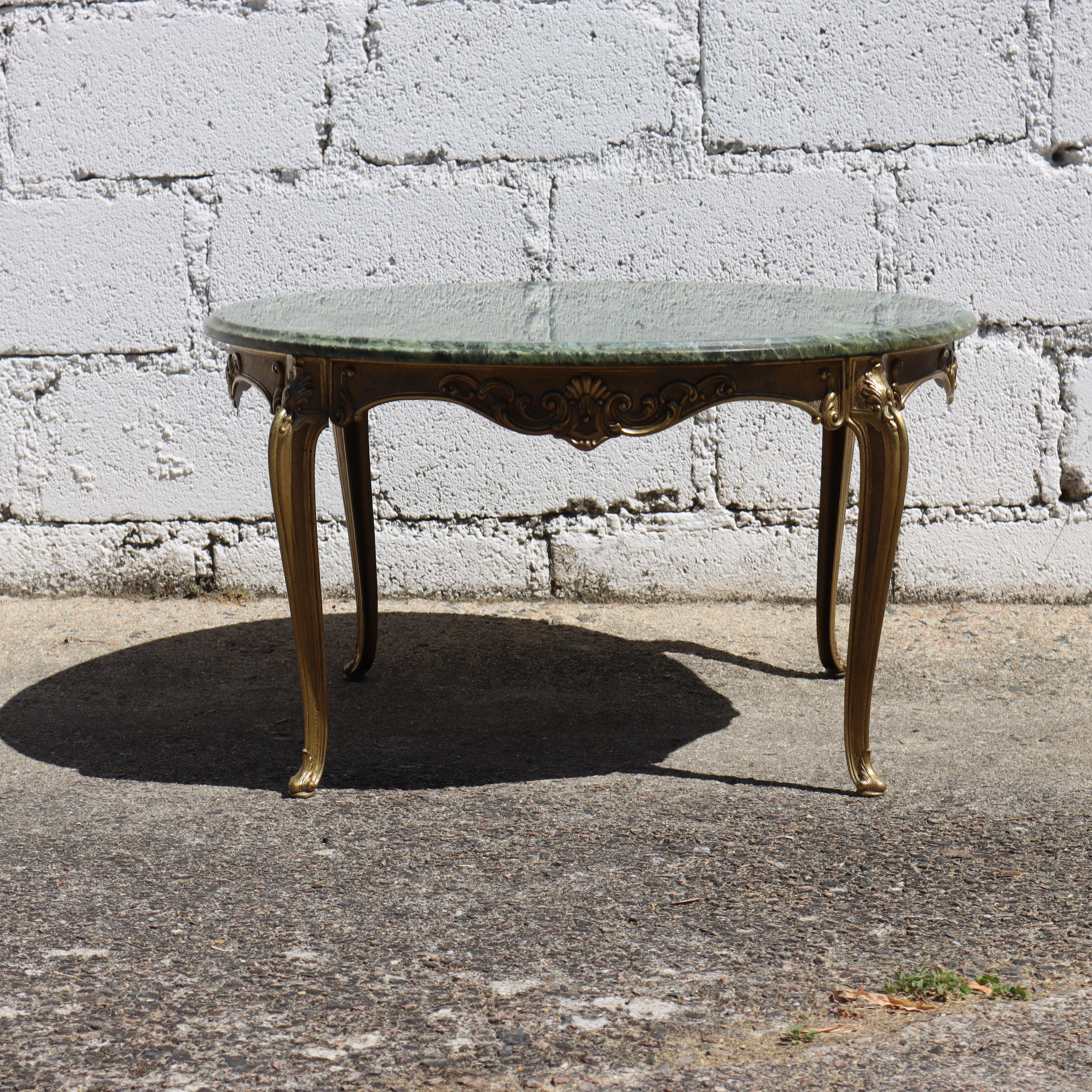 French Vintage big round Marble and Brass Coffee Table with an elegant emerald Marble Top, showcasing a stunning play of Colors with natural Patterns in Shades of emerald, jade, white, and black. 
The opulent Brass Frame is adorned with golden