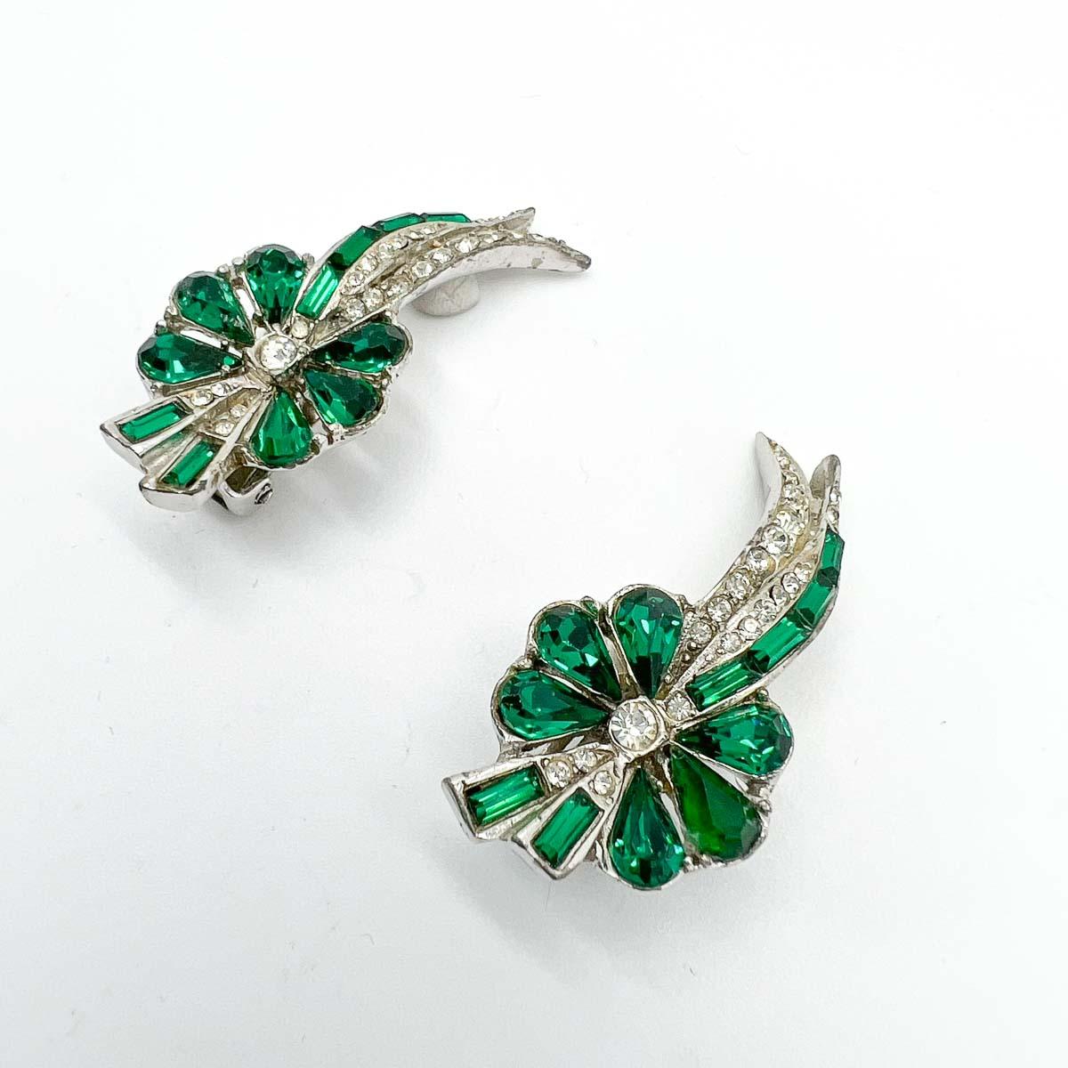 A delightful pair of original 1950s Vintage Emerald Paste Floral Earrings. Crafted with fancy cut emerald pastes in baguette and pear cuts, these are a beautiful example of mid-century jewellery and will prove eternally elegant.

An unsigned beauty.
