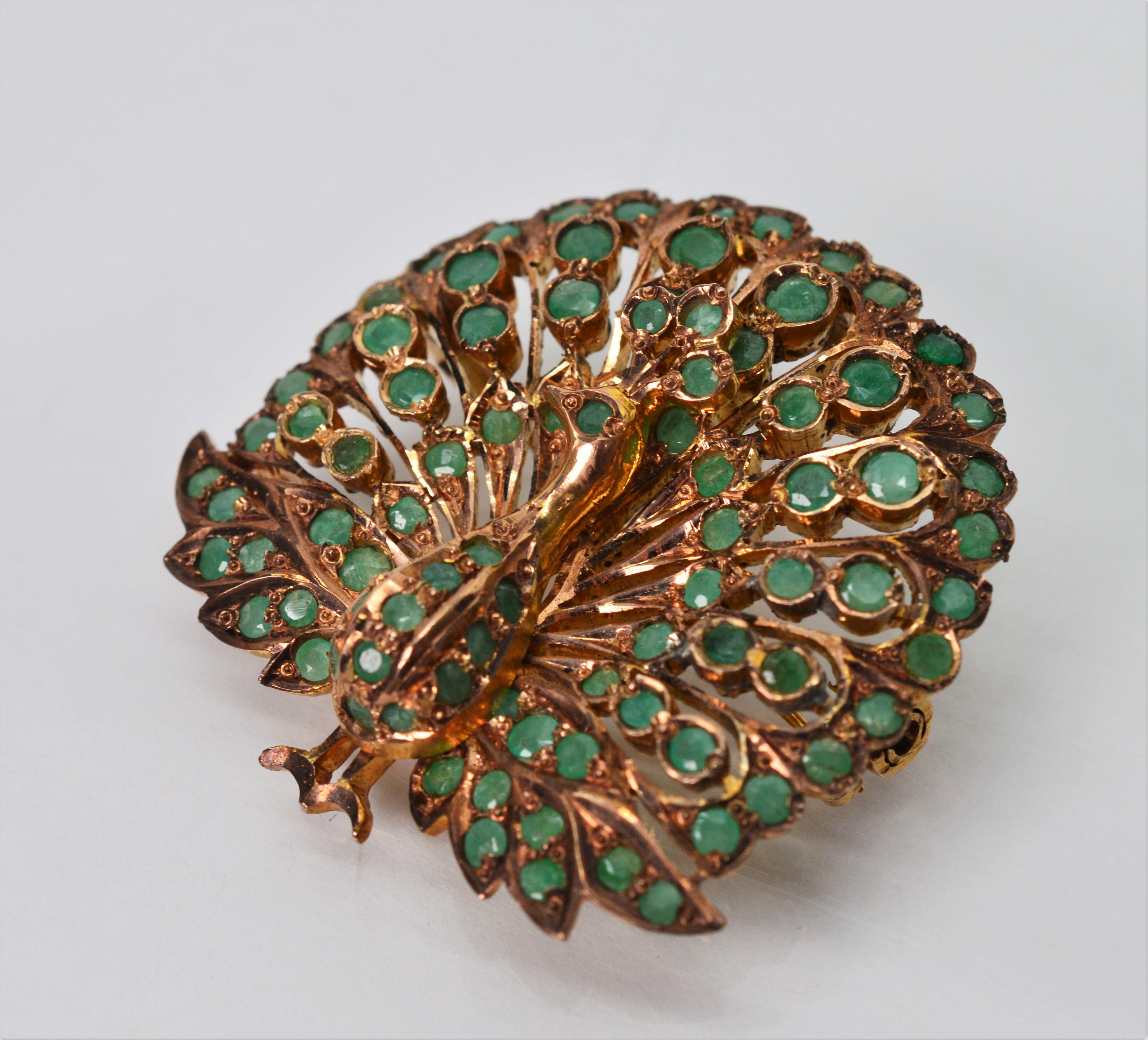 With emerald plumage proudly displayed, this glorious peacock brooch is sure to get attention. Made of seven carat 7 karat rose gold with a pleasing vintage patina and over seventy natural crude hand cut emeralds stones Two inches tall and 1-1/2