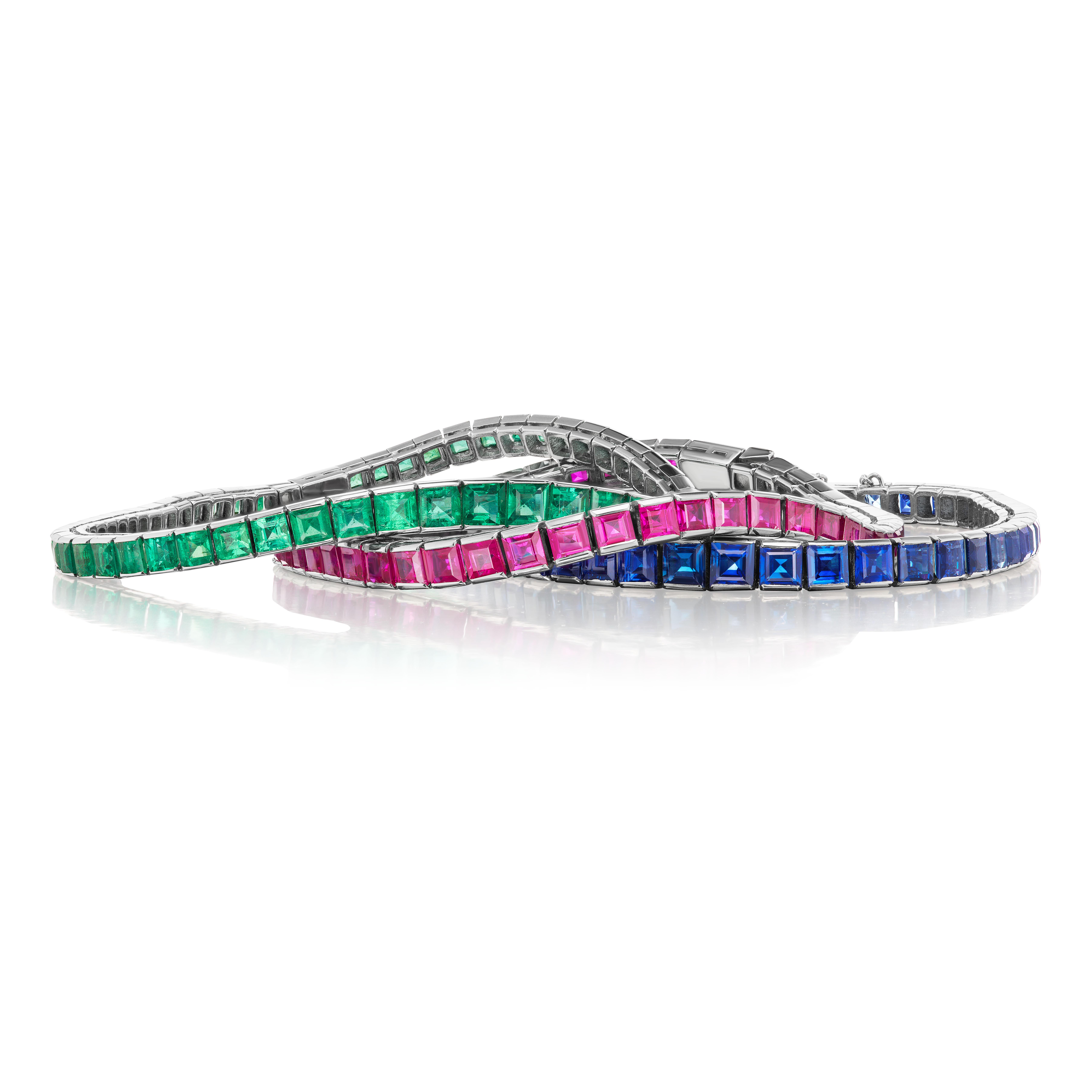This vintage 3 bracelet set featuring platinum channel set square-cut sapphire, ruby, and emerald bracelets makes a splendid fashion statement. The stones are very clean and are an excellent match in color. Each bracelet graduates slightly larger