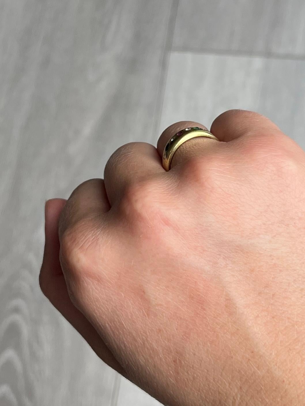 Dieses 8-karätige Goldband ist mit einem Rubin, einem Smaragd und einem Saphir besetzt, dazwischen liegen Diamanten. Die drei farbigen Steine messen jeweils 5 Pence und die Diamanten messen jeweils 3 Pence. 

Ring Größe: N oder 6 3/4 
Breite des