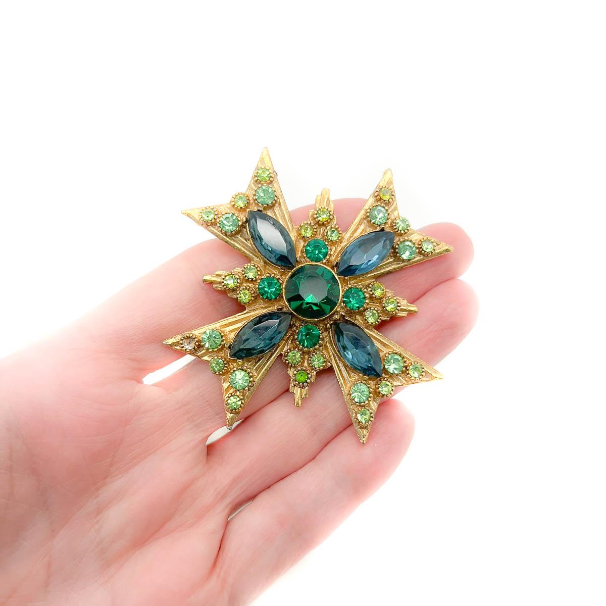 Broche cruciforme vintage en verre émeraude. Ce design intemporel est orné de pierres de cristal vert pâle, vert émeraude et saphir pour un effet à couper le souffle. Une épingle parfaite qui fera sensation à chaque fois qu'elle sera portée.
Une