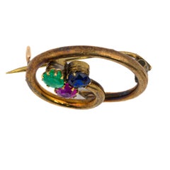 Broche circular vintage de esmeralda, zafiro y rubí