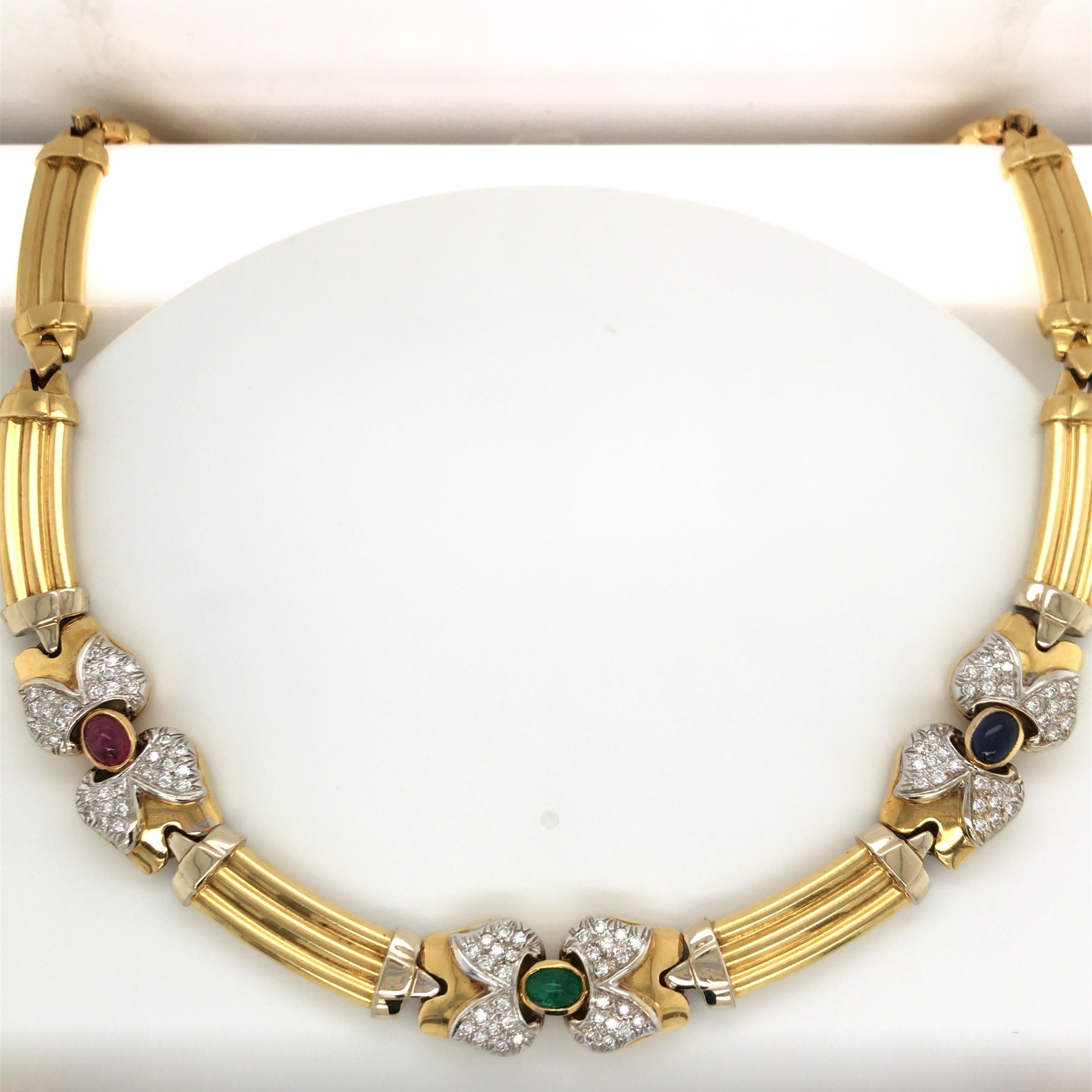 Vintage 18K Yellow gold necklace featuring three ovals of an Emerald, Sapphire and Ruby flanked with round brilliants in a bow motif. 