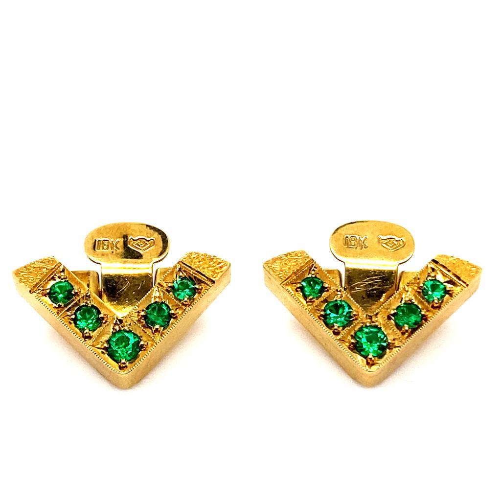 A pair of vintage emerald set 18 karat yellow gold corner pins, circa 1970.

These vintage corner pins are designed in yellow gold each featuring 5 grain set round cut emeralds of deep green in a V shaped design. The emeralds contrasting brightly