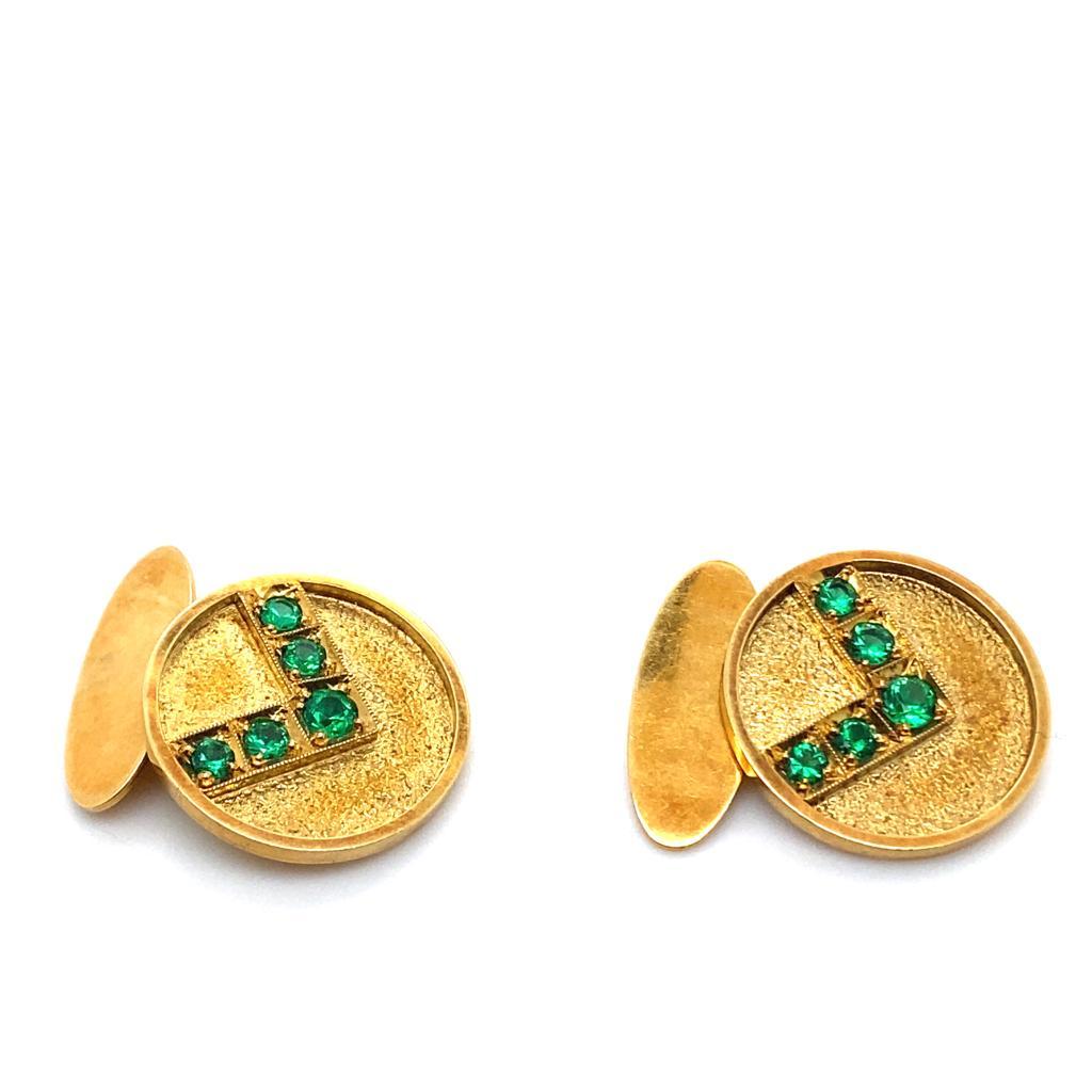 A pair of vintage emerald set 18 karat yellow gold circular cufflinks, circa 1970.

These vintage cufflinks are designed as matching yellow gold discs each featuring 5 claw set round cut emeralds of deep green in a V shaped design. The emeralds