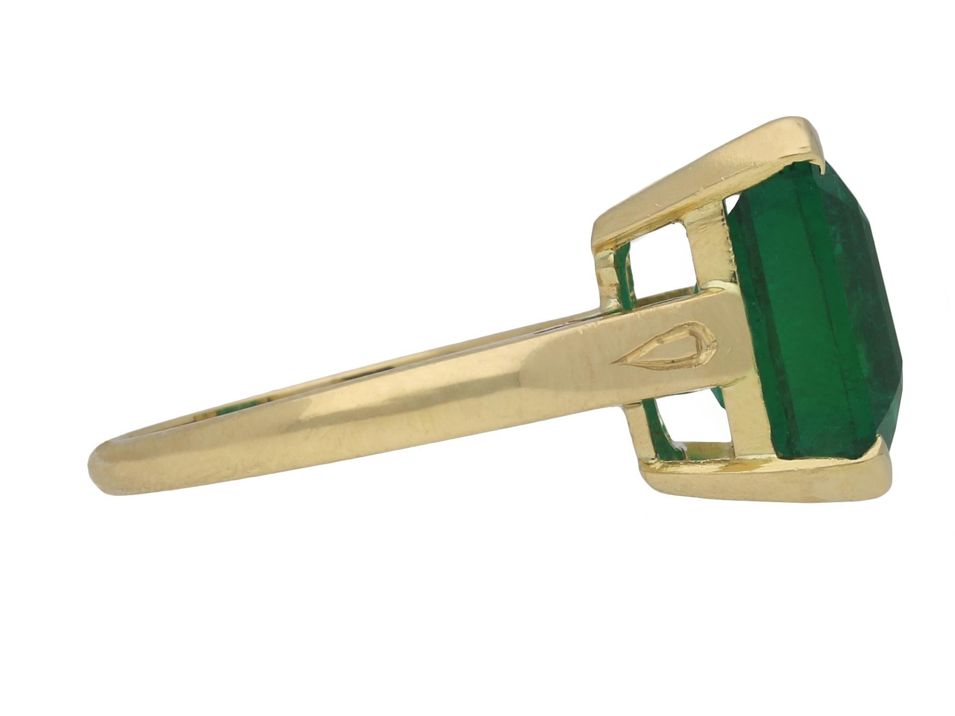 Vintage emerald solitaire ring. Centrally set with an octagonal emerald-cut natural Zambian emerald with moderate clarity enhancement in an open back claw setting with an approximate weight of 5.30 carats, to a striking solitaire design featuring