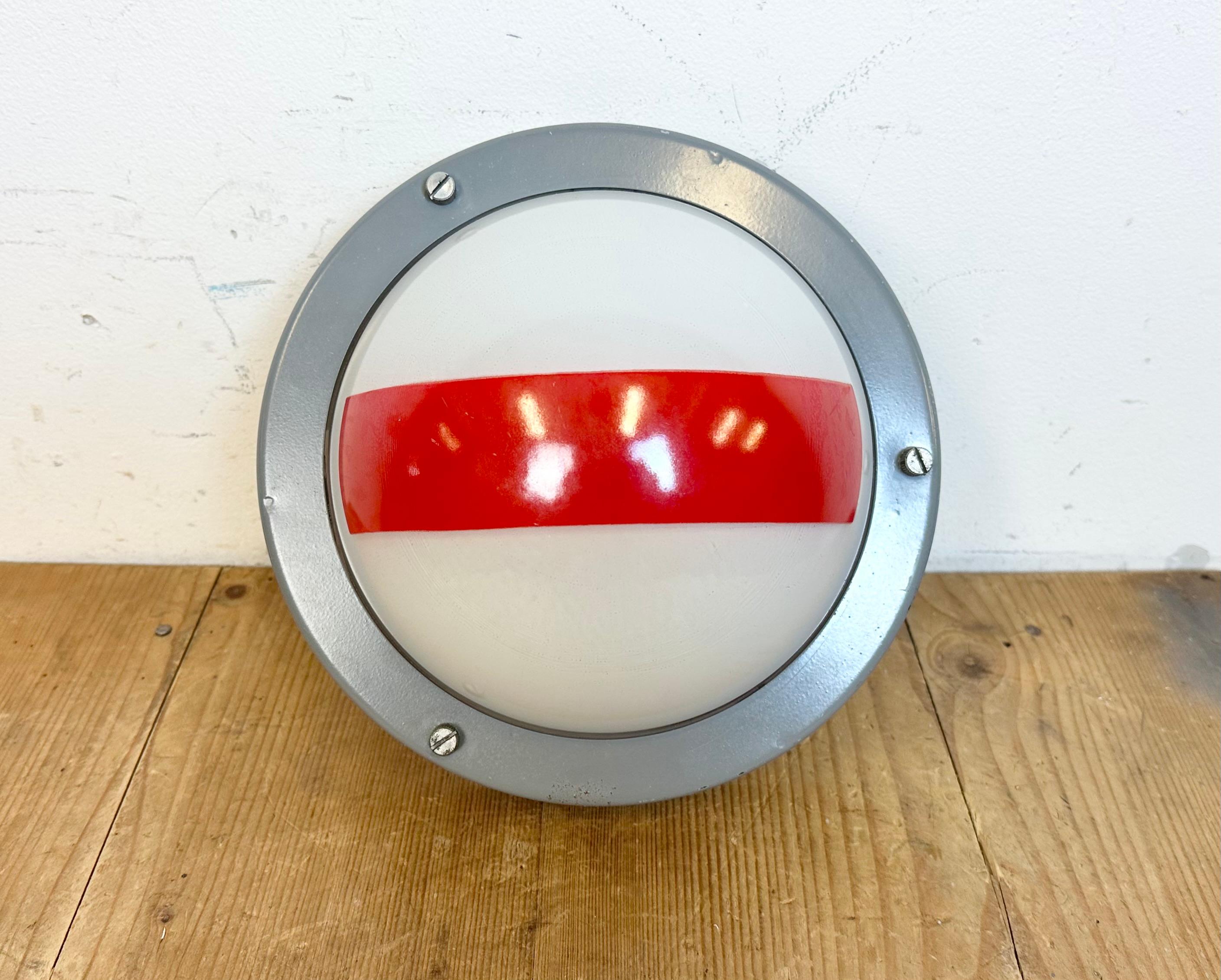 Vintage industrial emergency wall light made by Elektrosvit in former Czechoslovakia during the 1970s. It featutes a dark grey iron body and a milk glass cover.
The socket requires standard E27 / E26 lightbulbs. The diameter of the light is 24 cm.