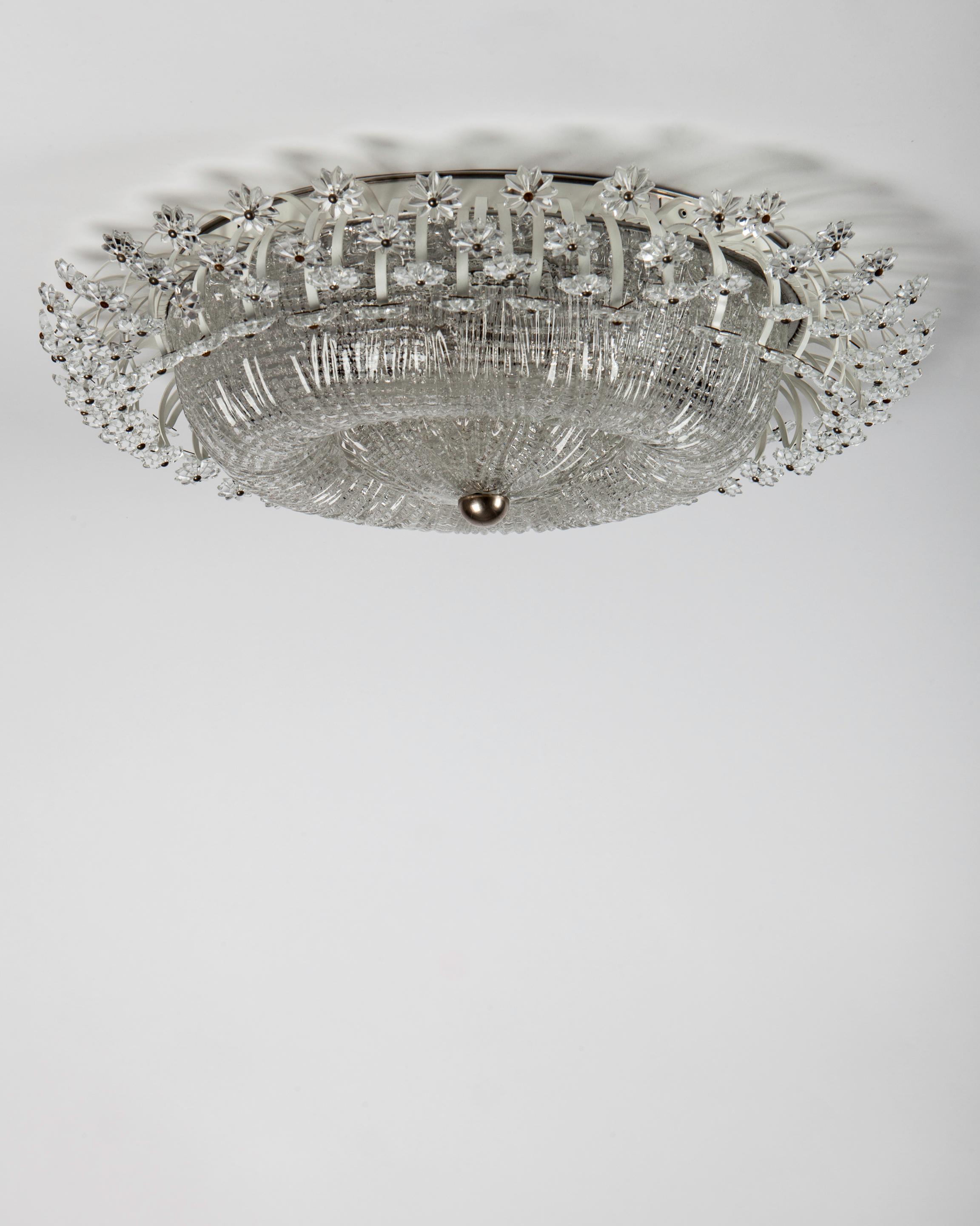 AHL4183
A vintage 1950s flush mount ceiling fixture having a thick textured cast glass dome lens surrounded by a spray of sparkling crystals in the shape of stars or flowers. The frame retains its original white lacquer finish and aged nickel