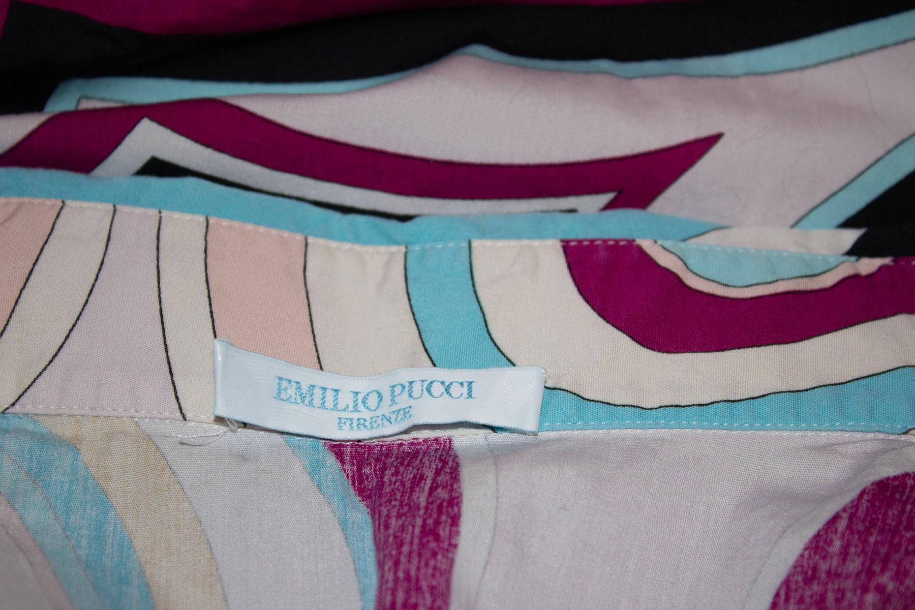 A stunning , and colourful vintage cotton shirt by Emilio Pucci. The shirt is in the iconic Pucci print with a white background and multi colour print. It has the original buttons, and has a button front opening with single button and turn back