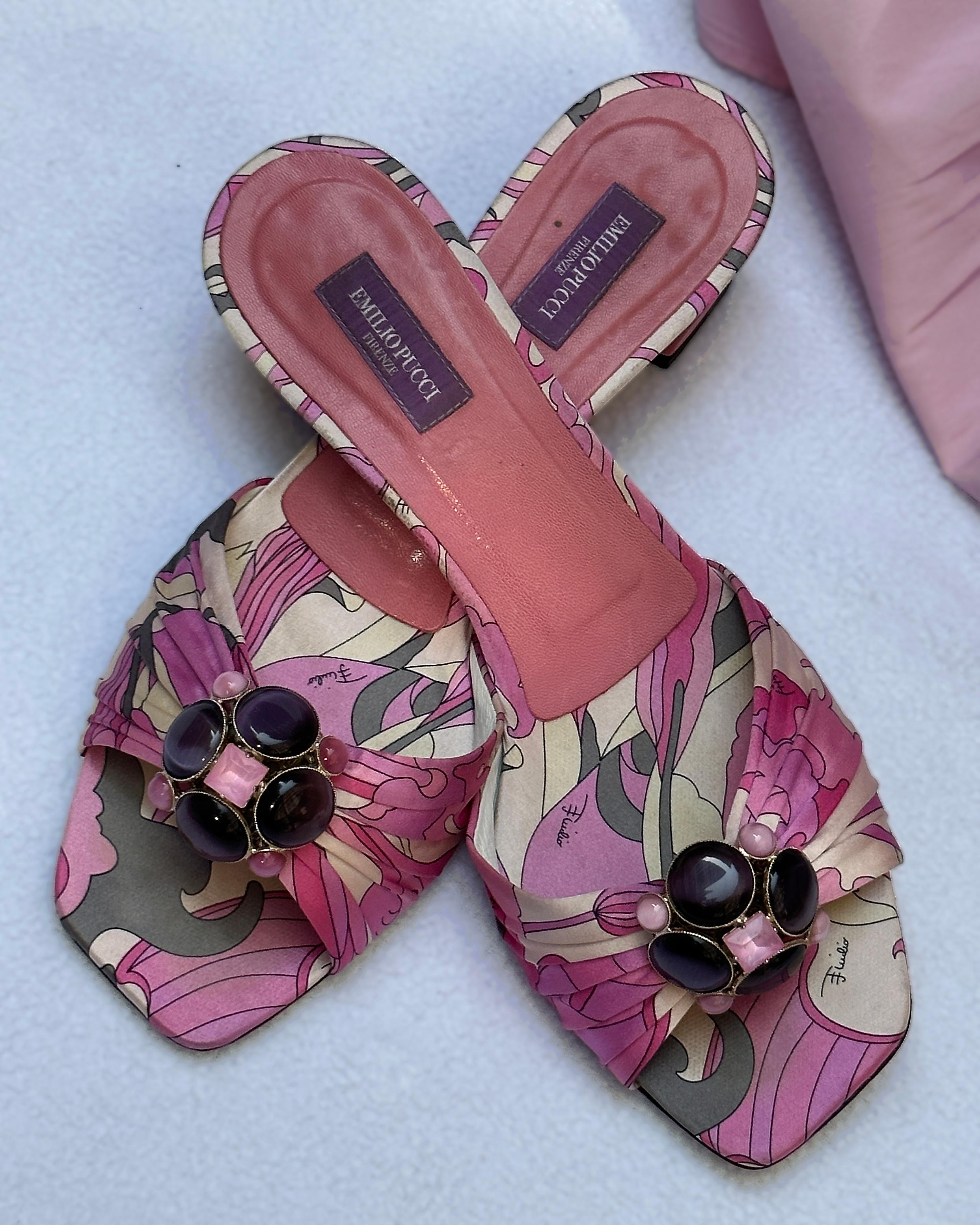These vintage Emilio Pucci slides transport you to a Slim Aarons photograph of Capri in the late 1960s. They're crafted of satin in a signature Pucci print, featuring vibrant shads of pink, purple, grey, and ivory. The gorgeous jewel embellishment