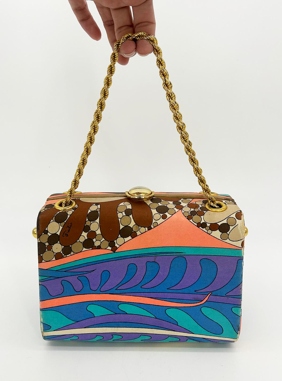 Vintage Emilio Pucci Silk Print Handbag c1960s in good vintage condition. Multicolor printed silk exterior in classic pucci style trimmed with gold hardware and double chain top handles. Top lift latch closure opens to a cream leather interior with