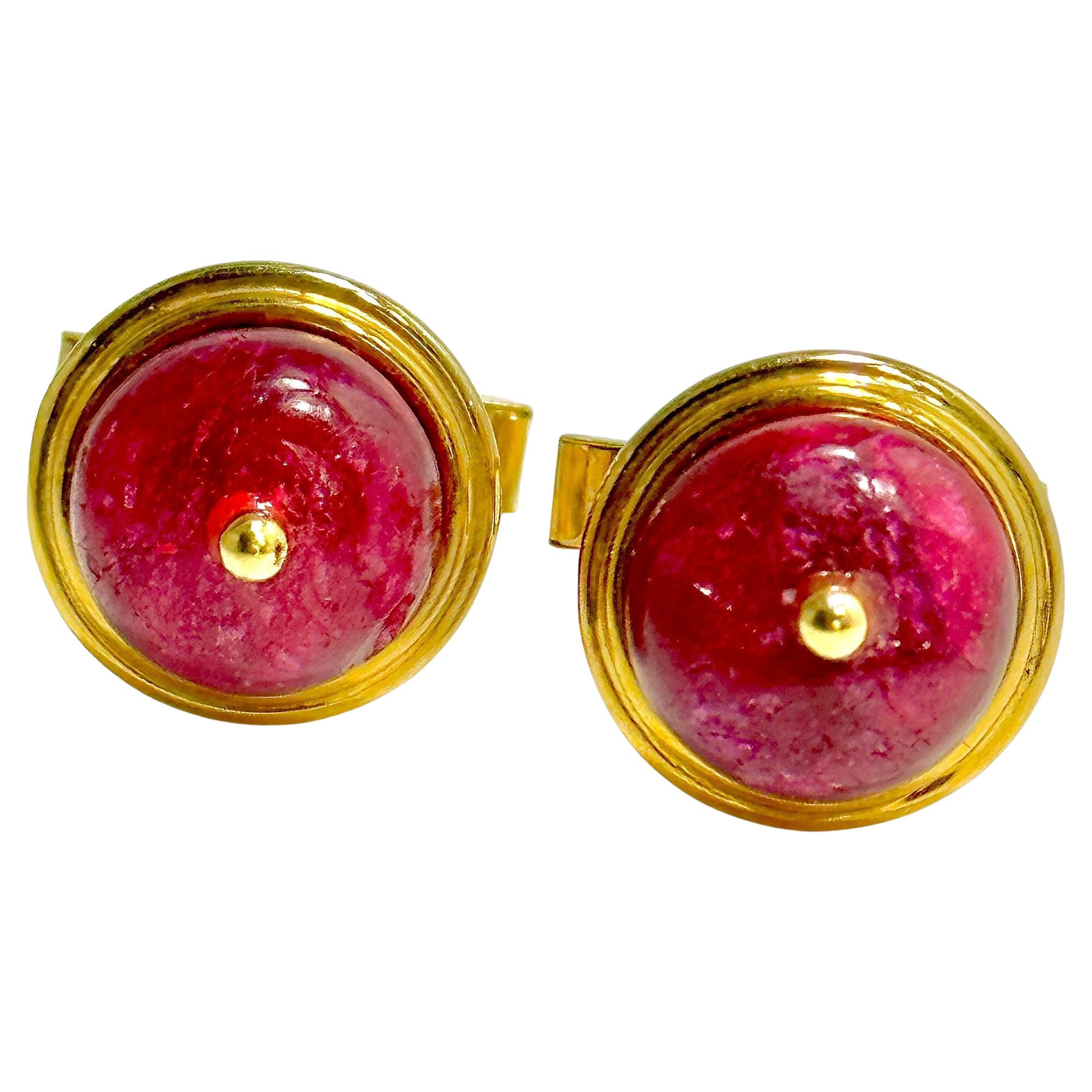 This artistic pair 18K yellow gold cuff links, created BY Emis Beros,  are each set with one 12.5mm natural ruby bead edged by a two level gold bezel. The effect is striking and entirely unique. Each cuff link measures 5/8 inches in diameter.
