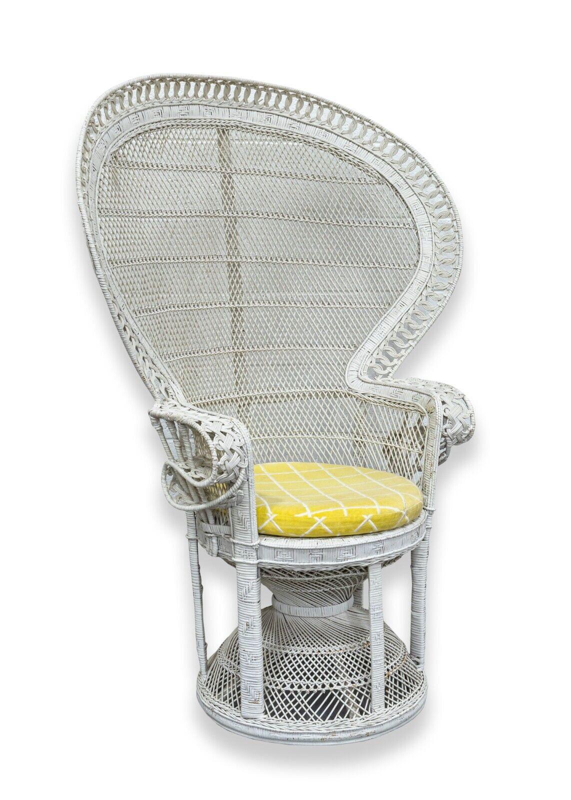 A vintage Emmanuel white wicker peacock accent chair with yellow seat cushion. A lovely wicker chair with a classic, vintage design. This accent chair features a woven wicker construction, a painted white finish, and a yellow with white stripe
