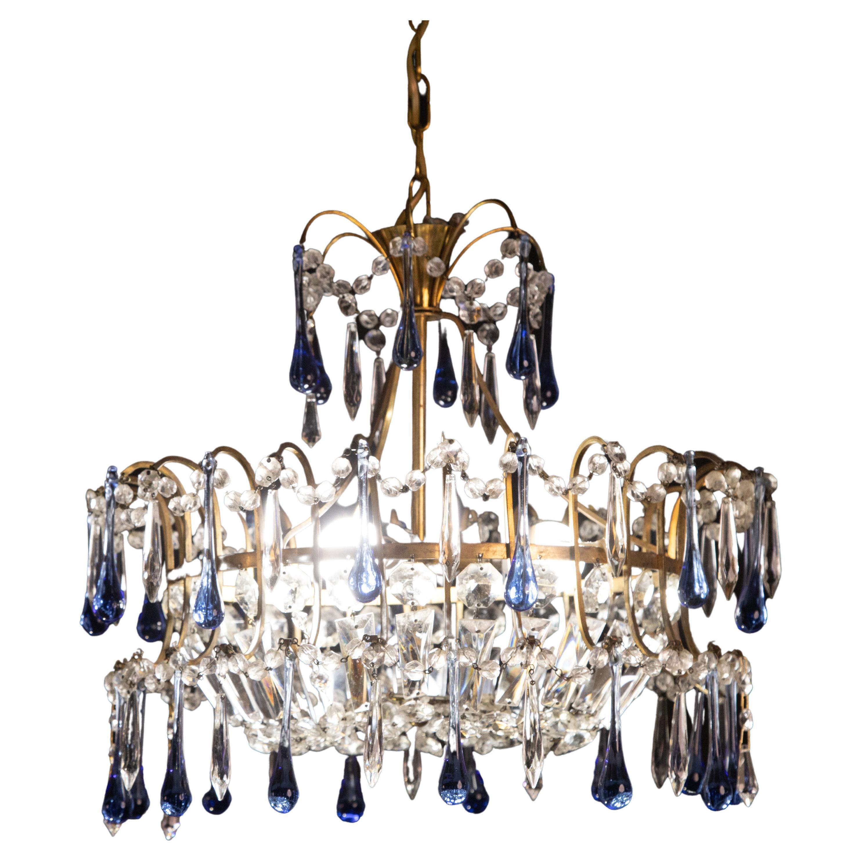 Emperor-style chandelier formed by rounds of crystals decorated with blue glass drops.


The chandelier is 100 centimeters high with the chain, 55 centimeters without the chain and is 45 centimeters wide.

It mounts three e14 lights.

A few crystals