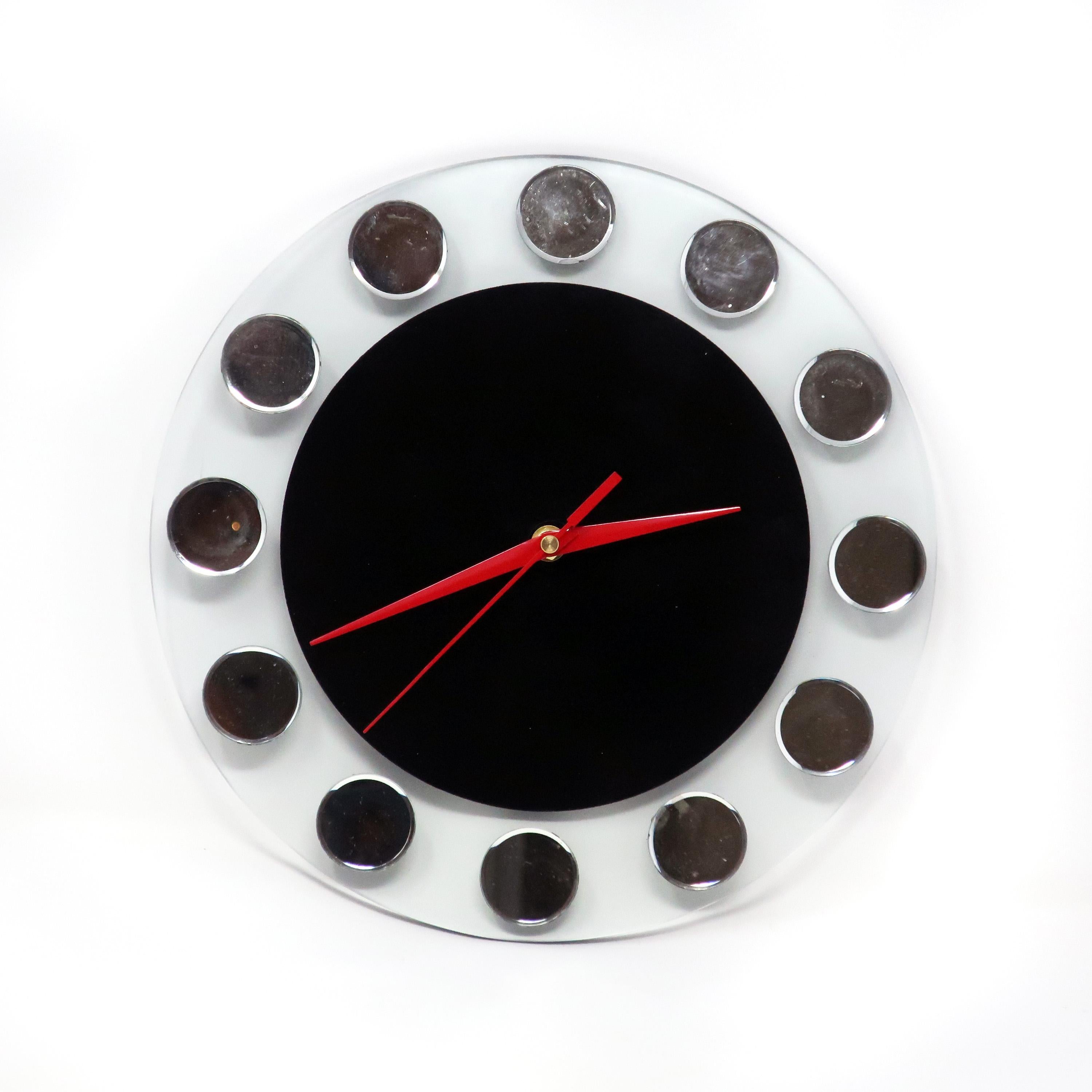 A Mid-Century Modern wall clock by Empire Art Products. On a clear round piece of glass, a black circle is reverse painted and twelve round mirrored pieces of glass are adhered for numbers. In good vintage condition with wear consistent with age and