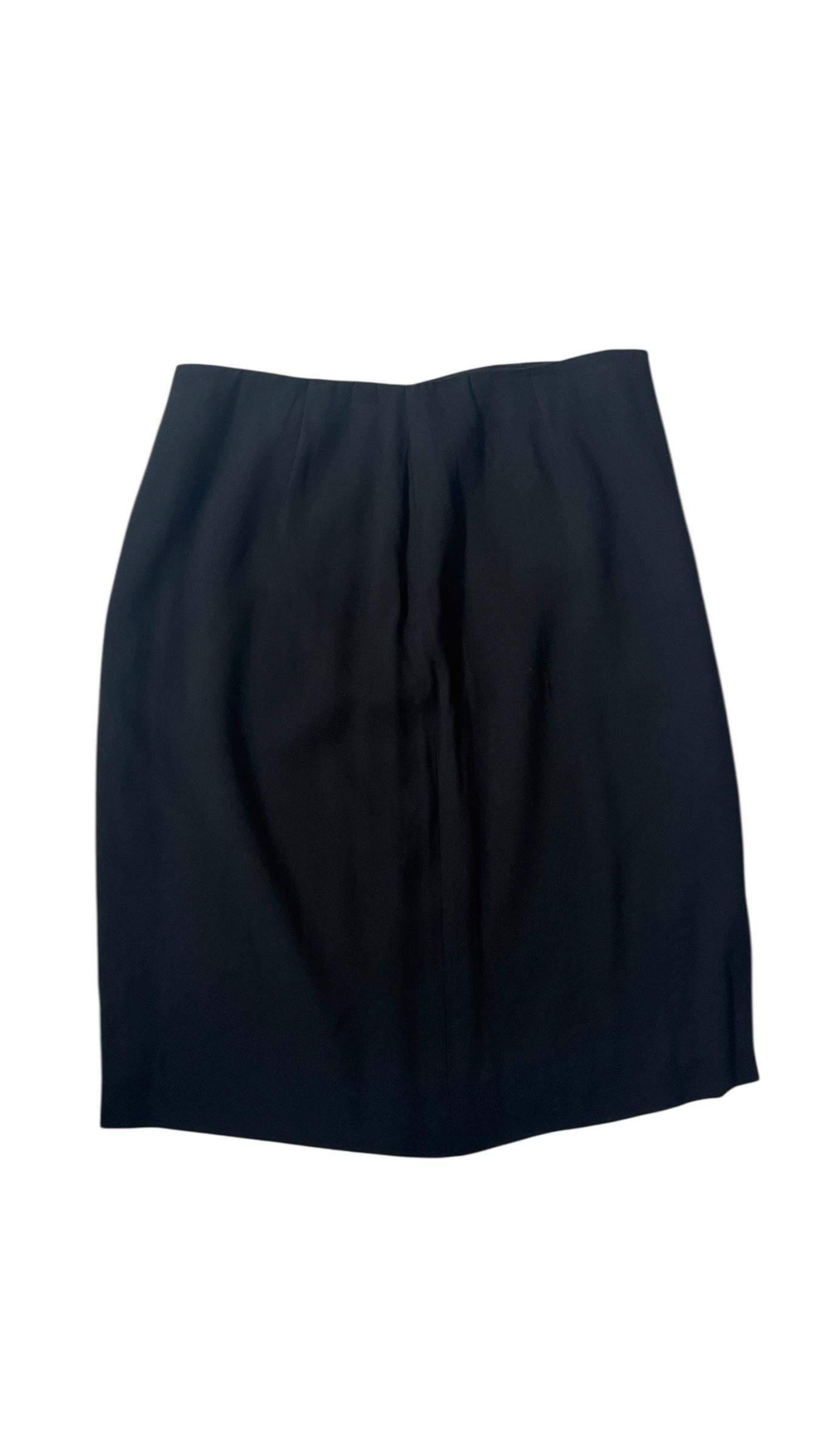 Elegant and minimal, this vintage Emporio Armani black wool mini skirt from the 1990s is a refined example of the brand’s timeless approach to feminine tailoring. Made in Italy, the skirt features a clean silhouette with subtle asymmetrical