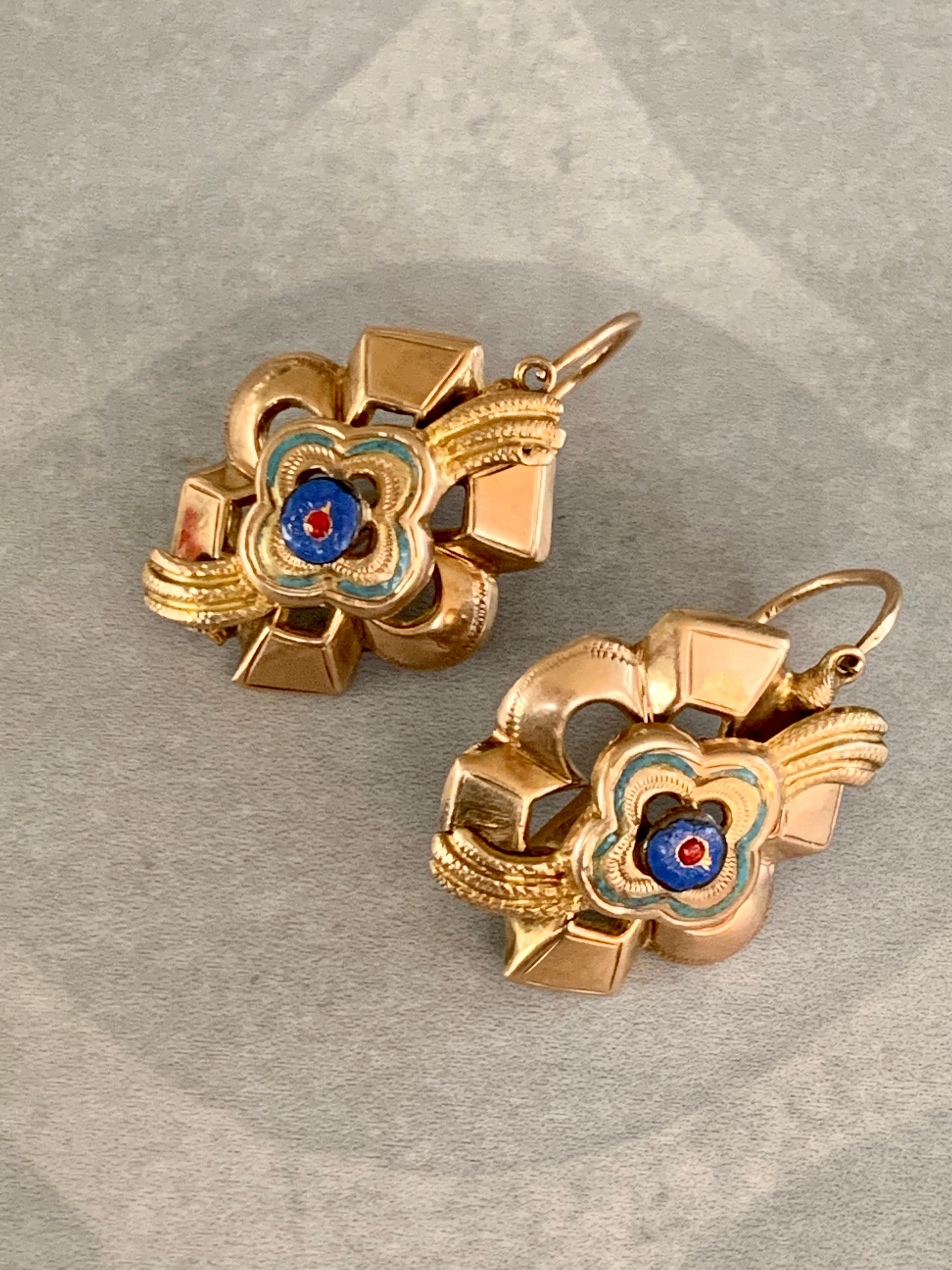 These pierced earrings are so intriguing.  The enamel work is beautiful.  The center of each earring has an enameled blue bead surround by green enamel; all in good condition.  The ear wires have a front closure.

Length: 1 3/8