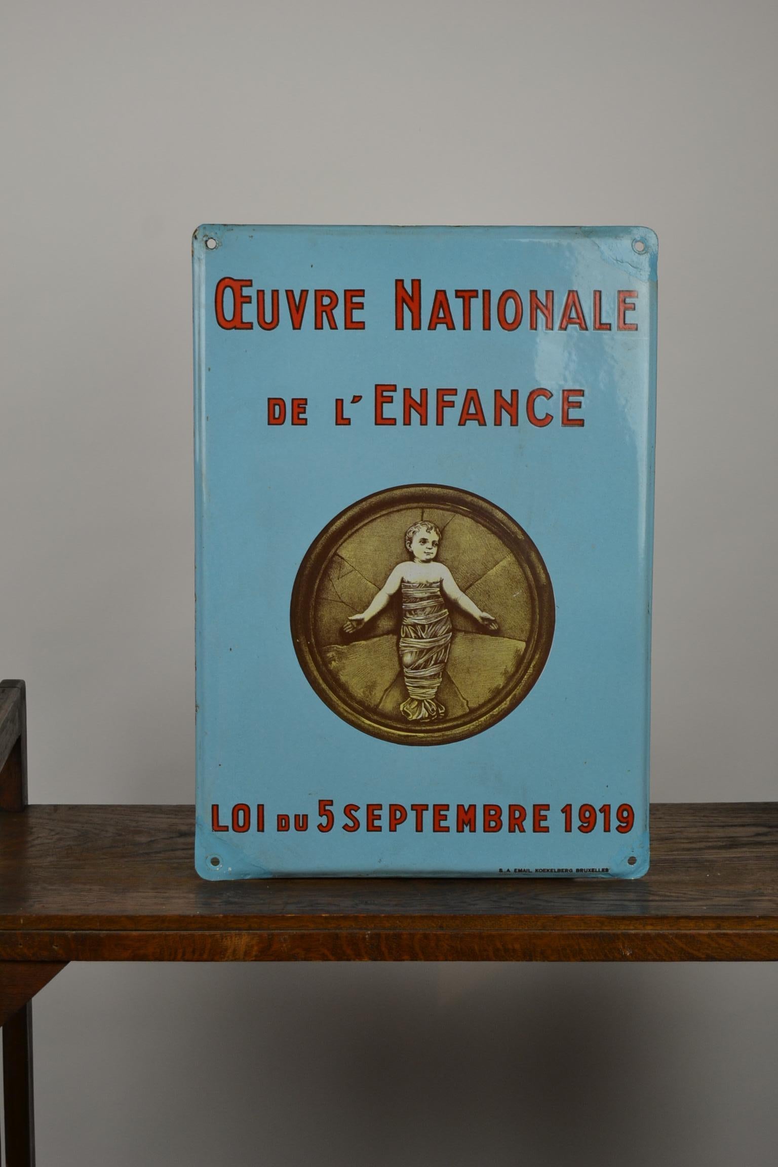 Rare enamel publicity sign - Door sign - Wall sign - Porcelain sign
for the National Child Welfare Work - Law of 5 September 1919 -
made in Memory of the Orphans after WW1. 

Light blue colored sign with an Image of a little Child - Baby.