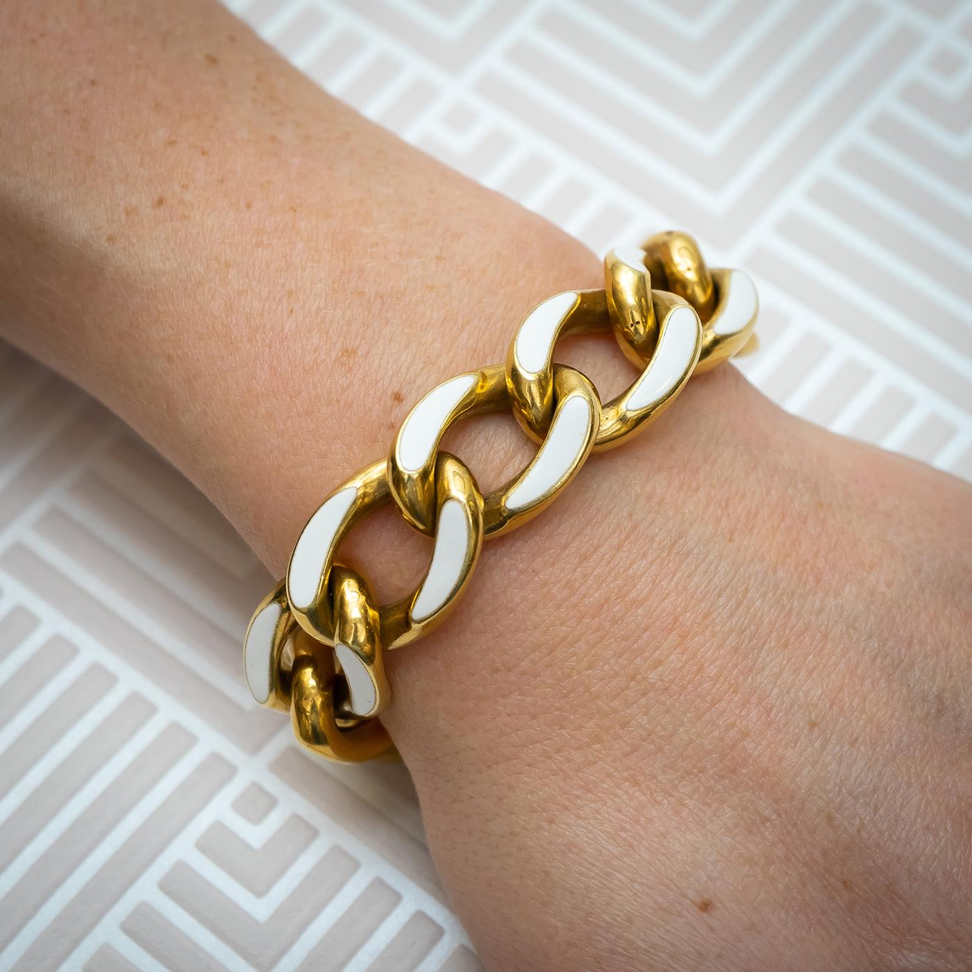 A vintage, enamel and gold, curb link bracelet, with a chunky, 18ct gold, hollow curb link chain, with white enamel on the flat top edges, with a concealed clasp, circa 1960.