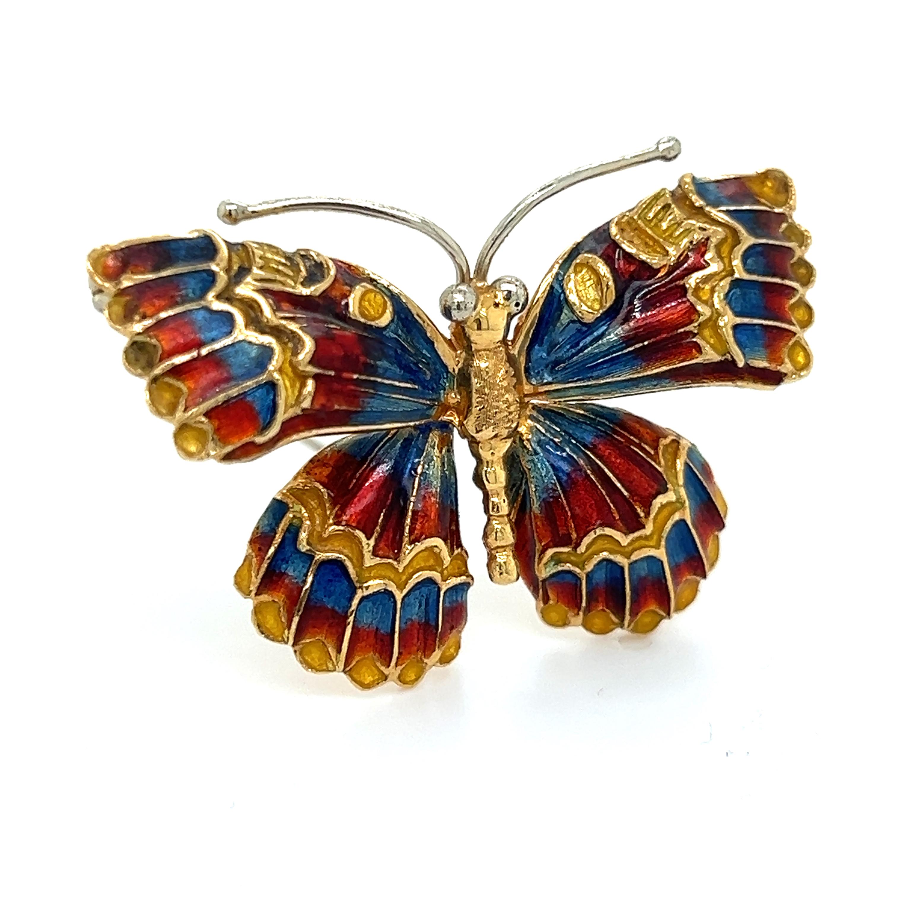 Beautiful brooch crafted in 18k yellow gold. The brooch is in  the form of a butterfly with exquisite detail throughout. The brooch is highlighted with vibrant colored enamel that pops off the design. Electric shades of orange, red, blue and yellow