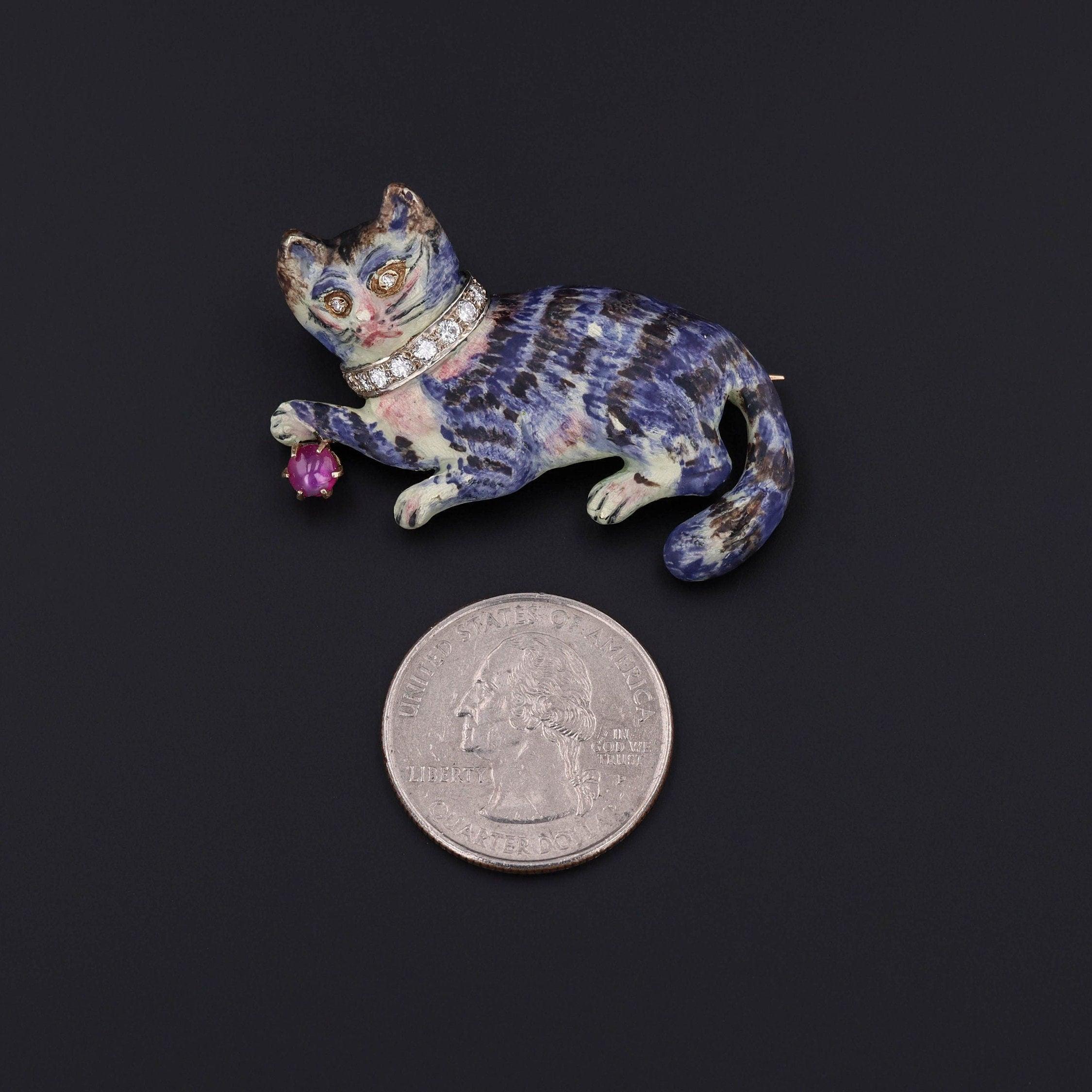 A purr-fect, brooch for anyone with a fondness for felines!

This vintage piece (circa 1960-1975) features a hand painted, 14k gold cat with a collar of diamonds and a single star ruby 'ball