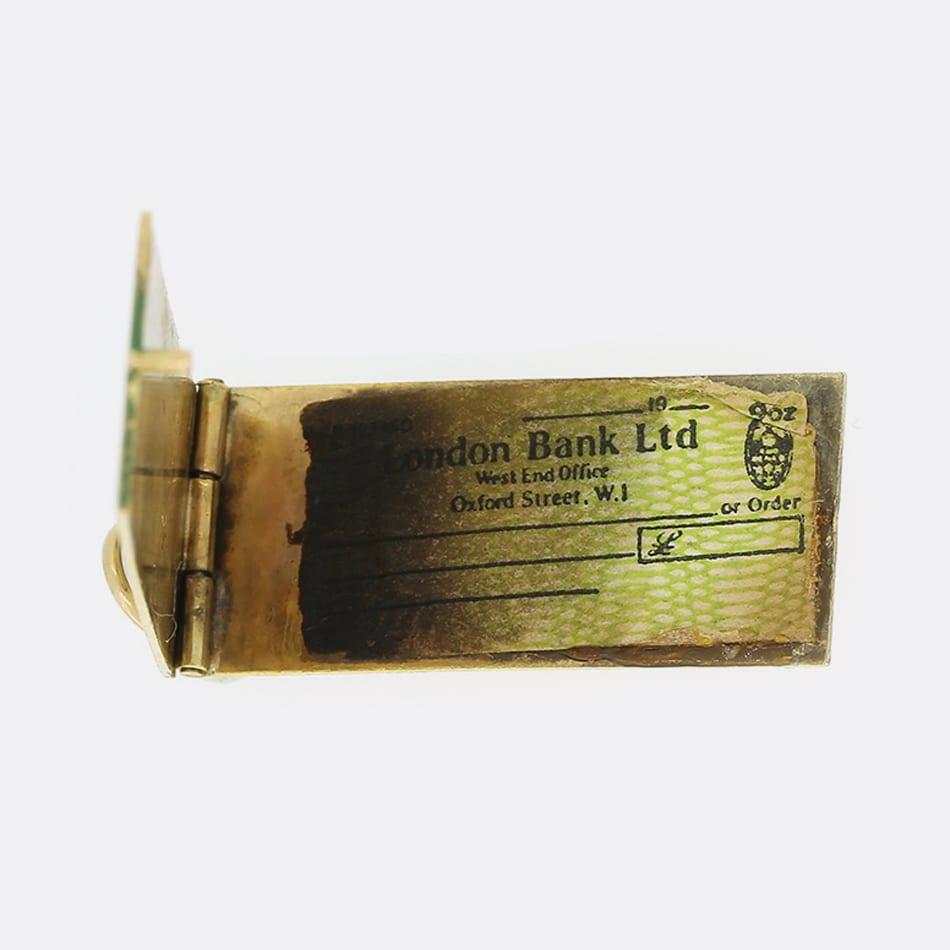 This is a highly detailed vintage 9ct yellow gold opening old fashion enamel cheque book charm. Marked 'CHEQUE BOOK' on the front while the blank cheques are marked London Bank Ltd.

Condition: Used (Very Good)
Weight: 2.9 grams
Dimensions: 25mm x