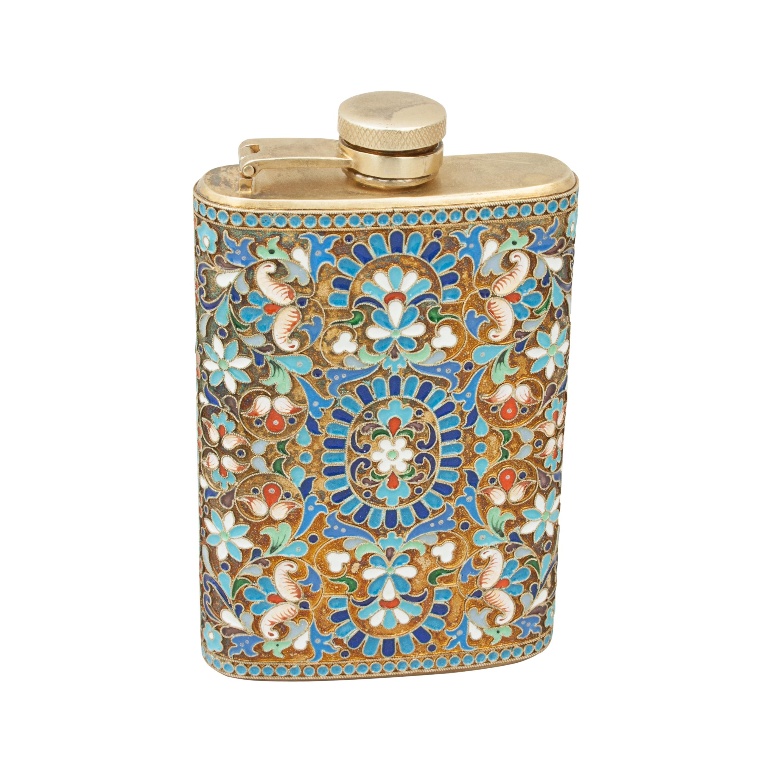 Vintage Cloisonné and silver hip flask.
A very nice silver hip flask with a curved body, hinged lid with screw fitting and decorated throughout with coloured foliage enamels between blue beaded borders and on a gilt metal background. The flask is