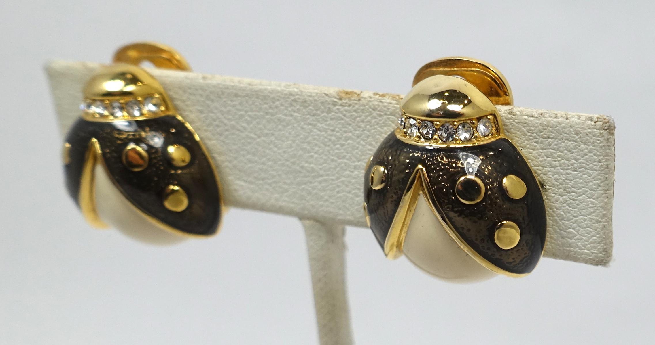 These vintage earrings feature a ladybug design with black and white enameling and clear crystals in a gold tone setting.  In excellent condition, these clip earrings measure 3/4” x 5/8”.