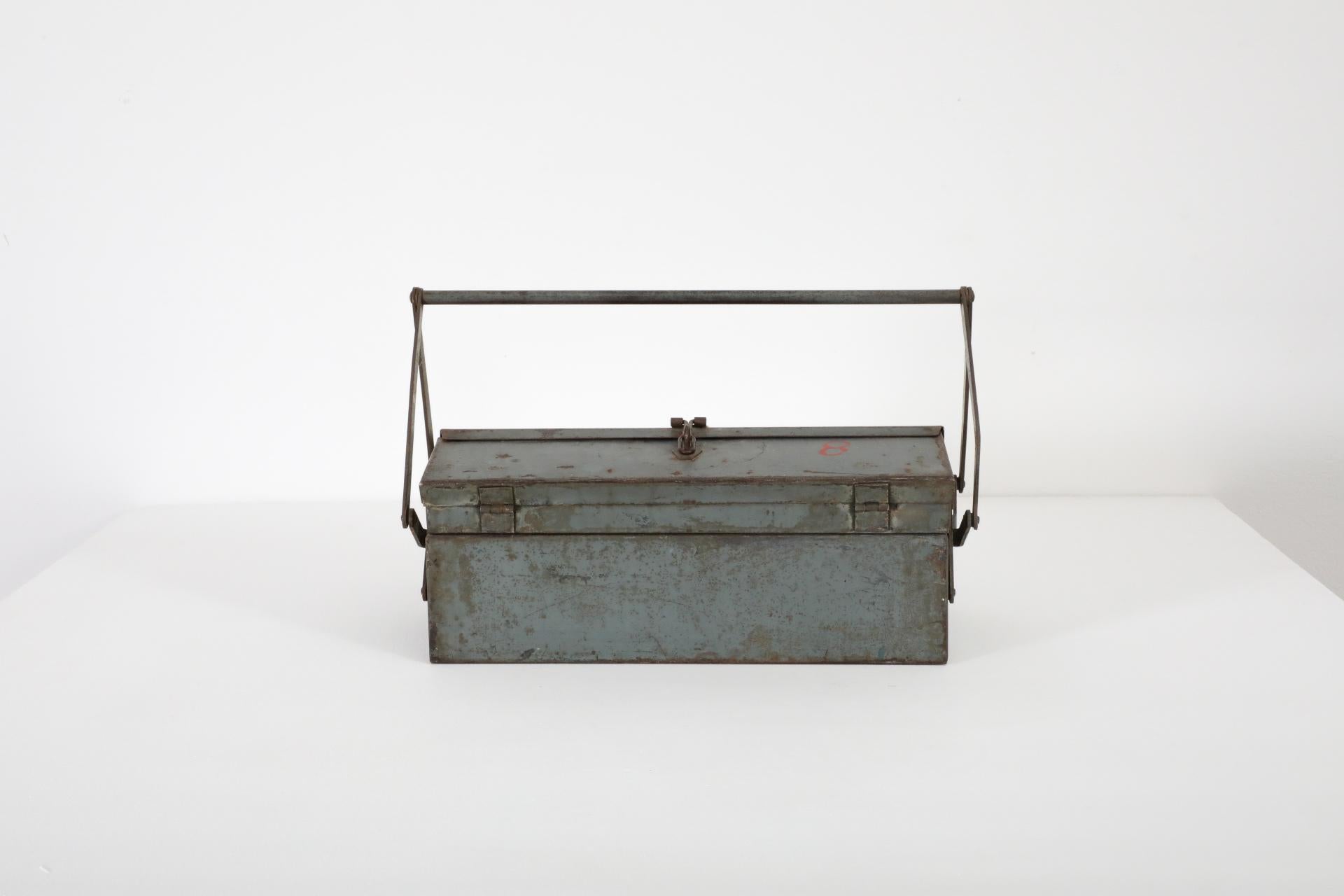 Vintage light blue metal tool box with handle and stacking trays. Label reads 'VEB Starkstromamlagenhau Cottbus', presumably a construction plant in Germany. In original condition with visible wear, including enameled loss, discoloration and