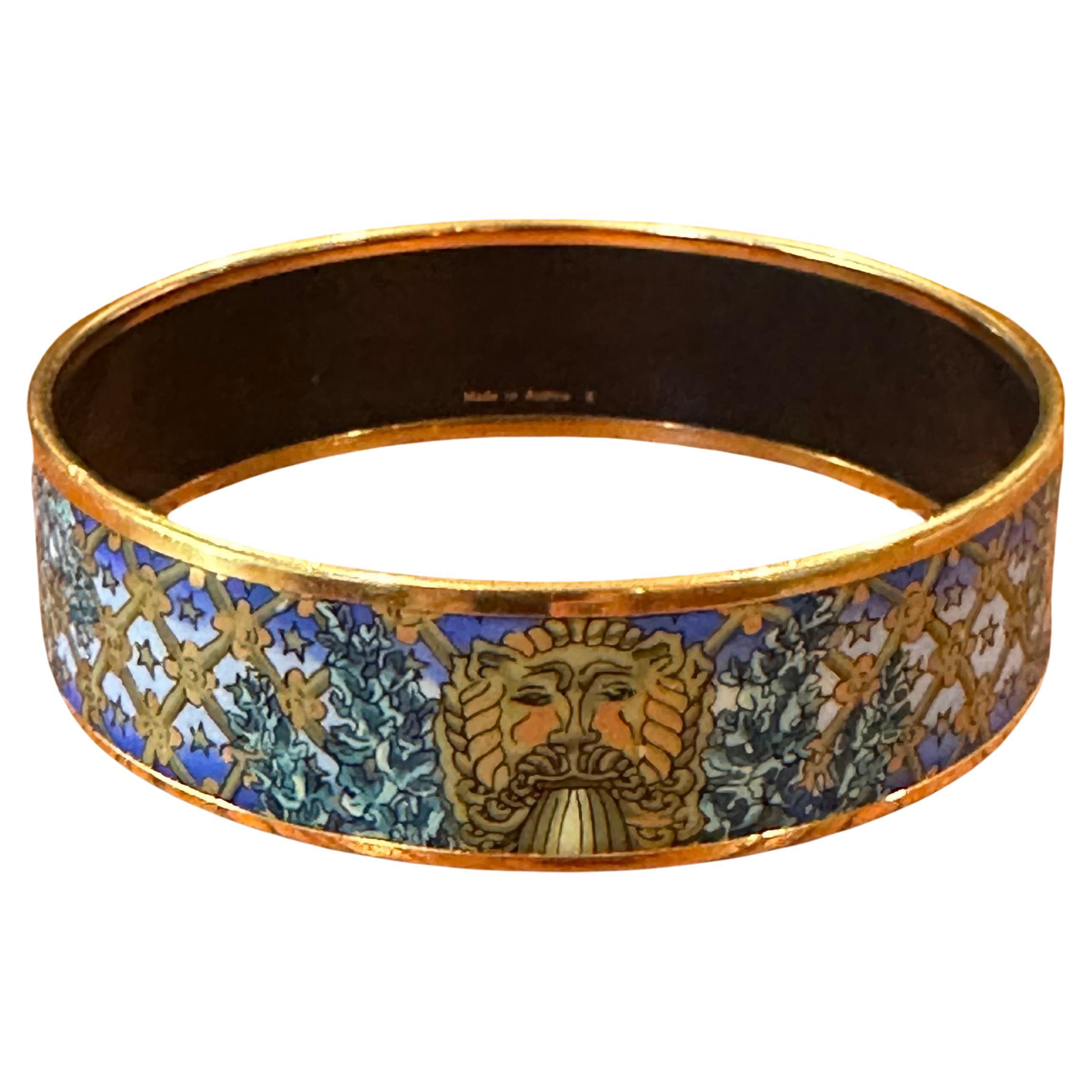 Vintage enameled and gold plated lion head bangle bracelet with original box and ribbon by Hermès, circa 1990s.  The bracelet is in very good vintage condition and measures 2.75