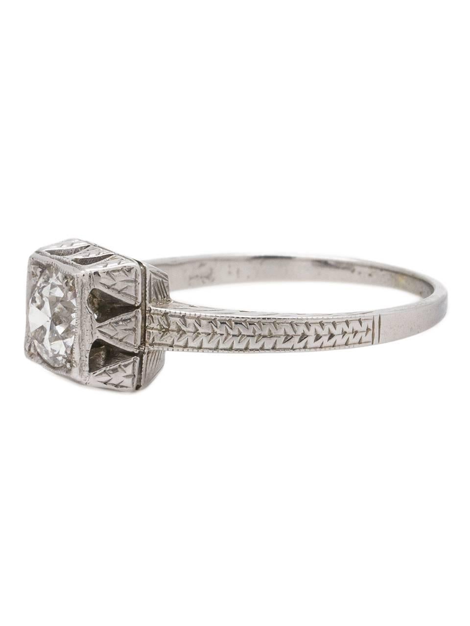 
Stunning 18K white gold Art Deco diamond engagement ring showcasing an EGL certified 0.79ct transitional cut round center stone, E (colorless)-SI1. This intricately adorned setting features an elevated square illusion setting, with wonderful