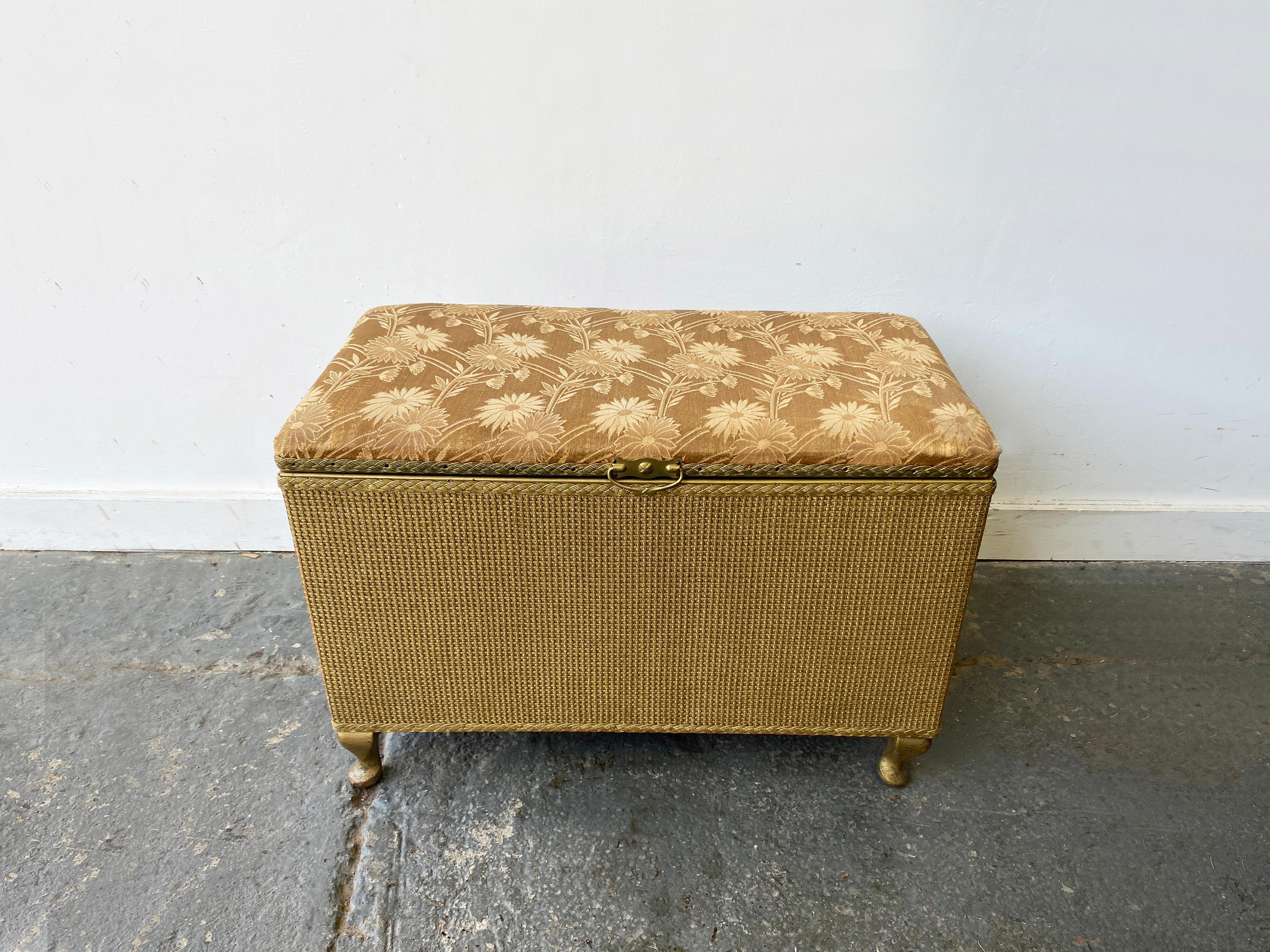 Cassapanca / portacoperte / pouf d'epoca in stile Lloyd Loom in canna dorata e lino satinato, in ottimo stato di conservazione.
Rivestito in tessuto satinato oro con motivo floreale. Siede su gambe cabriole.

Consegna
I costi di consegna indicati