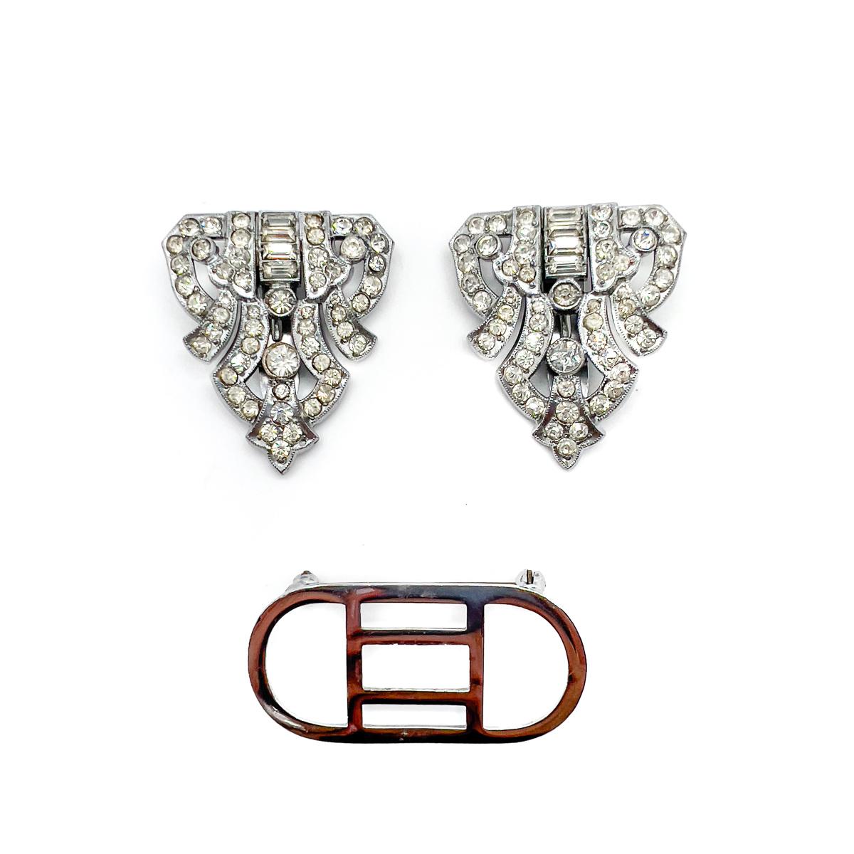 A Vintage English Art Deco Paste Double Dress Clip Brooch. Wear as a brooch or as a pair of dress clips. An effortlessly stylish work of Art Deco craftmanship.
During the 1920s & 30s the Art Deco style reigned supreme. The bold new look flowed