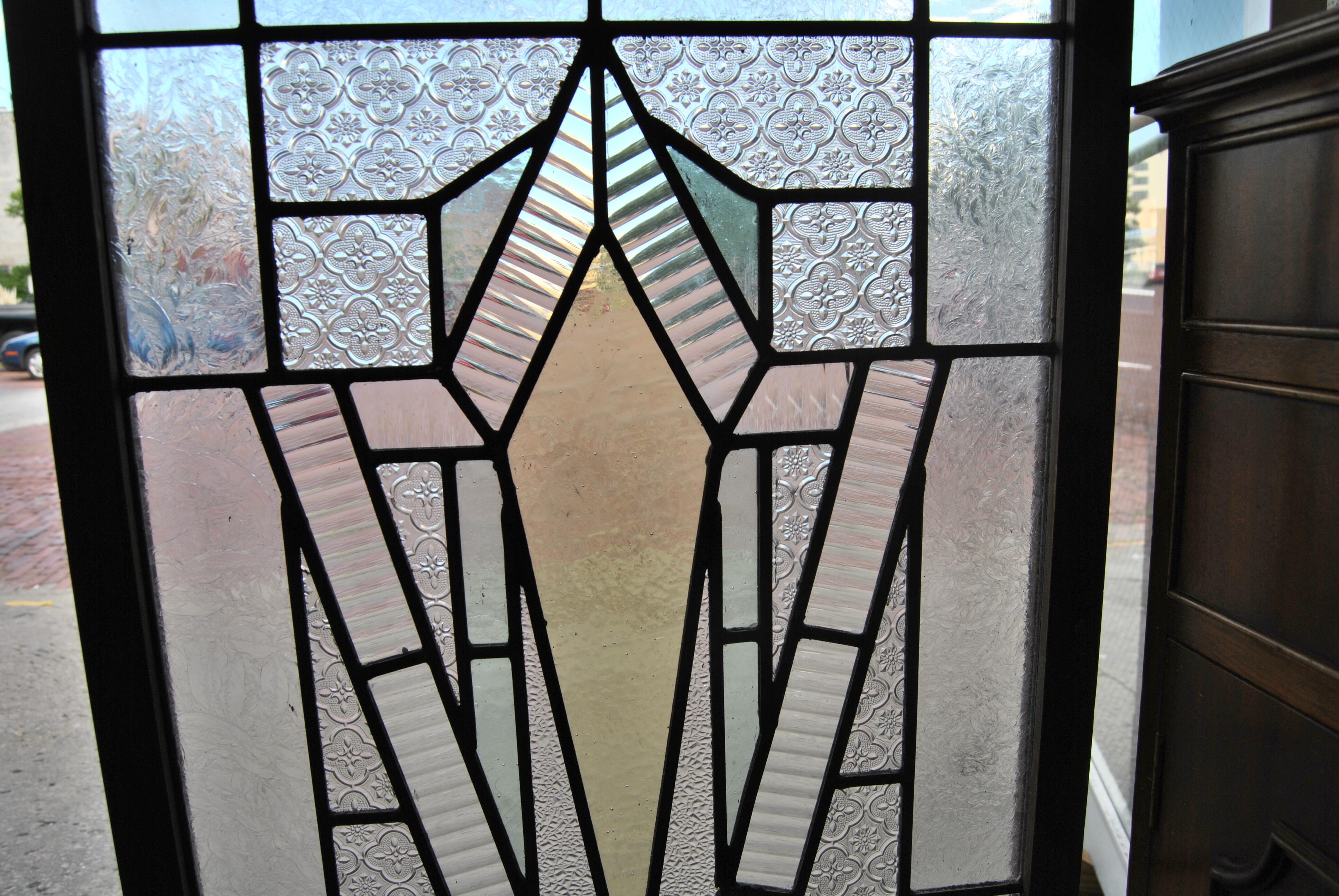 This is a stained glass window made in England, circa 1970. It has a combination of colors being light gold / yellow, light green, blue and clear. The window is done in a wonderful Art Deco style. It is clean and sound with no cracks or breaks. It
