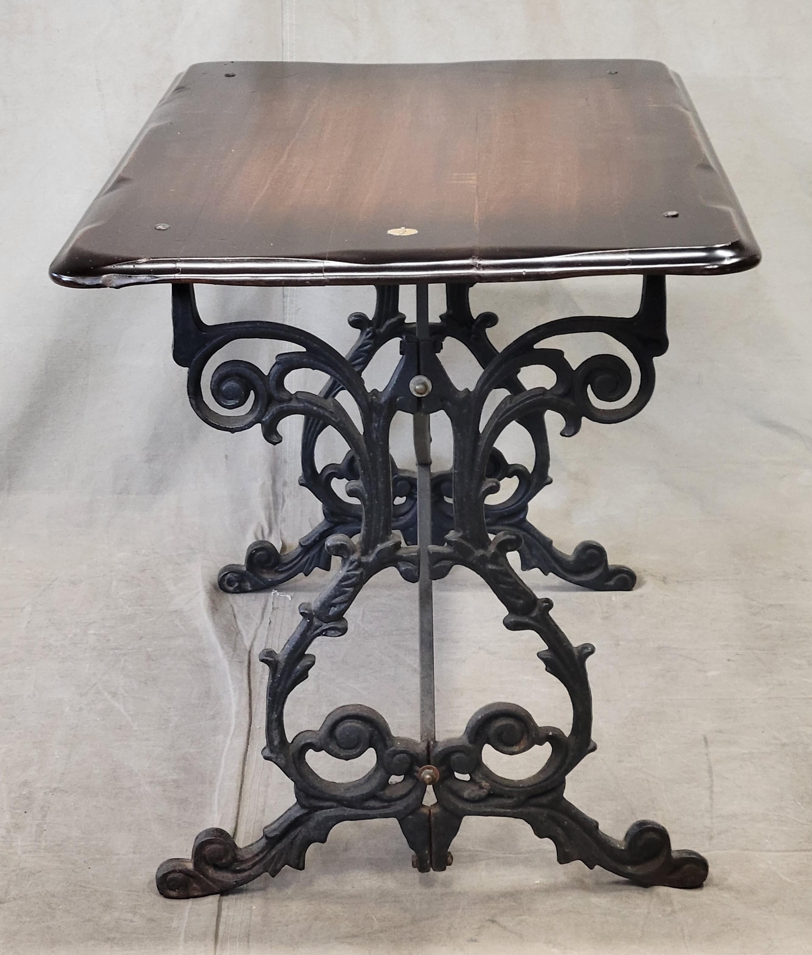 Such a fun piece! This vintage authentic English pub table has a dark mahogany wood top on a black cast iron base. A round number 2 plaque is inset in one end. Perfect for a set of 4 English pub stools or narrow chairs as a petite kitchen or