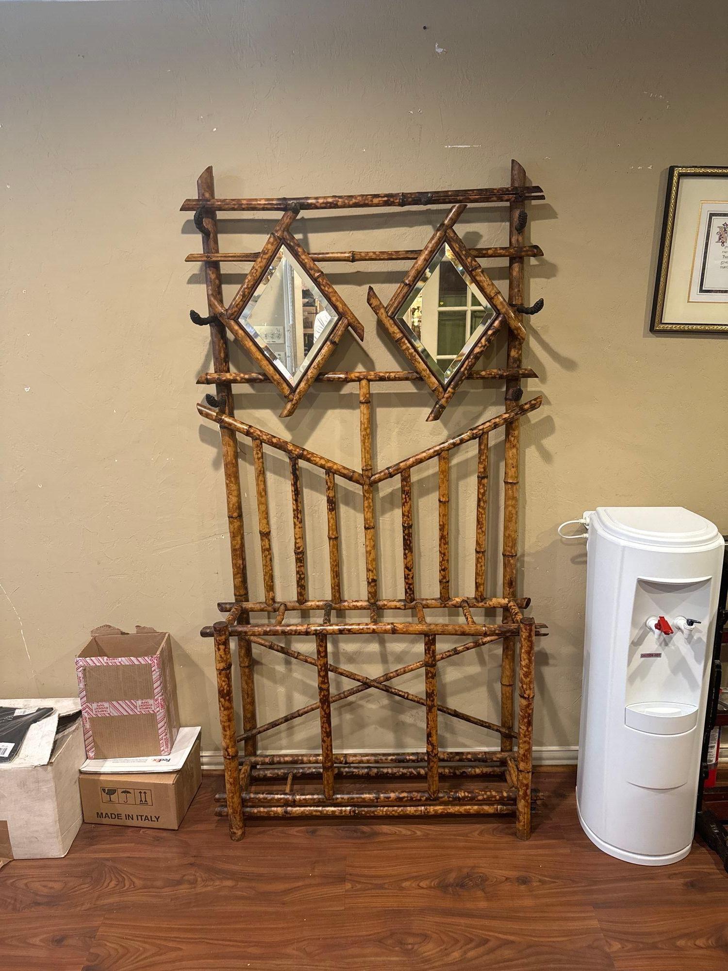 Portabandiera in bambù vintage inglese dell'inizio del XX secolo. Tutto originale con pannelli a specchio smussati a forma di diamante. 6 ganci per cappotti o cappelli e divisori per ombrelli. Un pezzo funzionale e interessante per il design di
