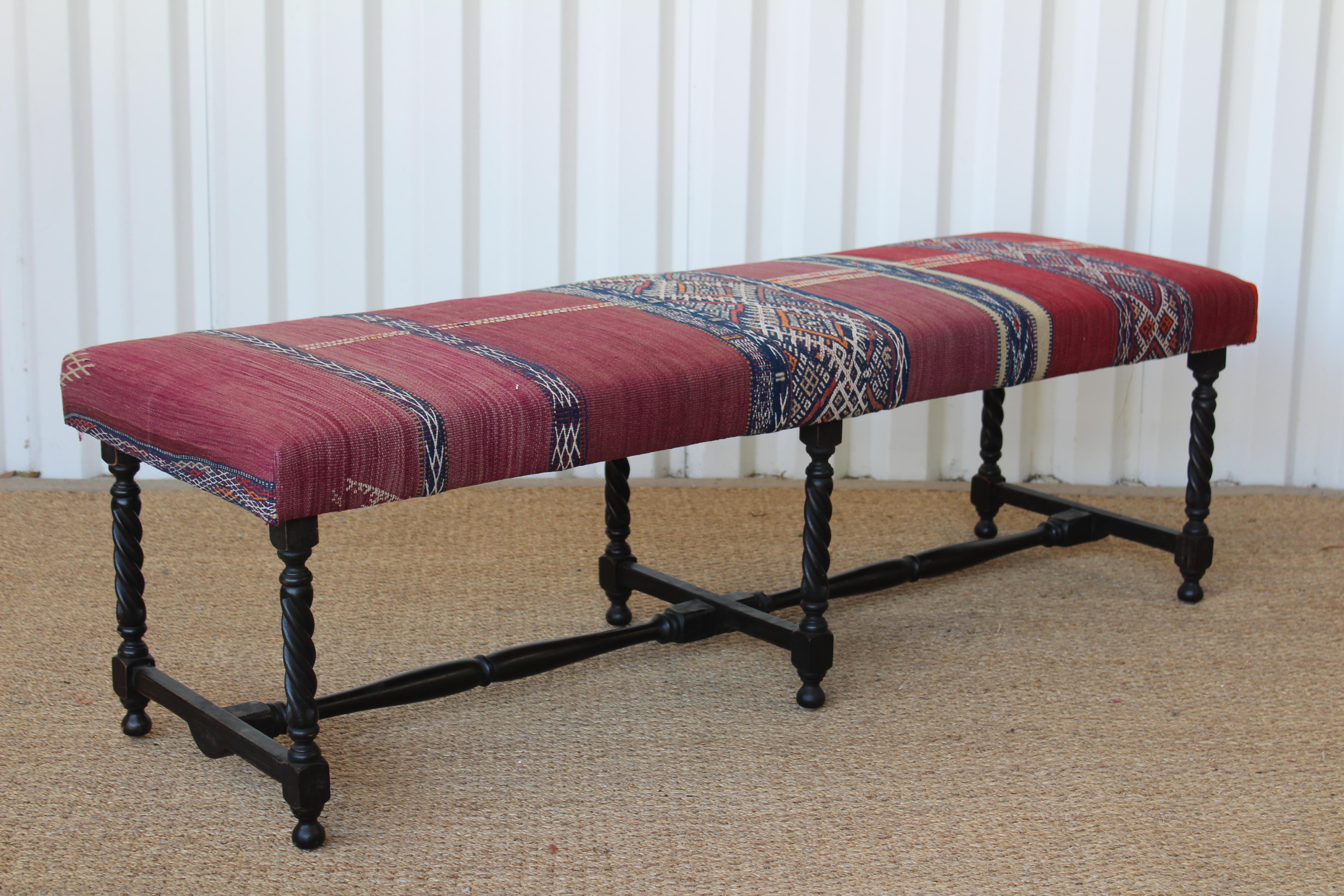Vintage turned wood English bench, newly upholstered in a vintage Turkish kilim rug. In overall excellent condition with minor signs of age on both the wooden bench frame and vintage rug.