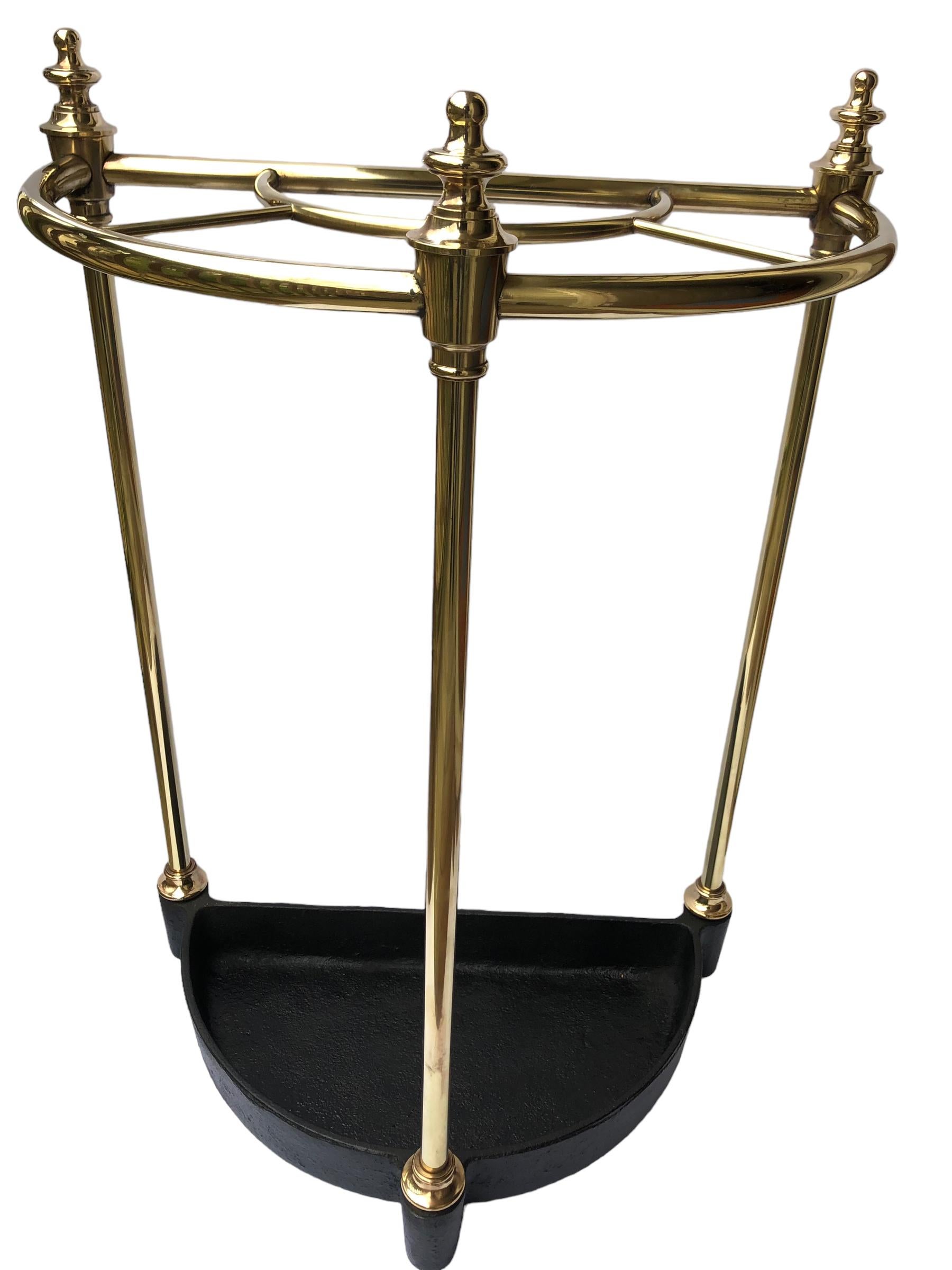 Vintage solid brass English brass and cast iron umbrella or stick stand. Half round construction with five slots for holding your umbrellas or walking stick.