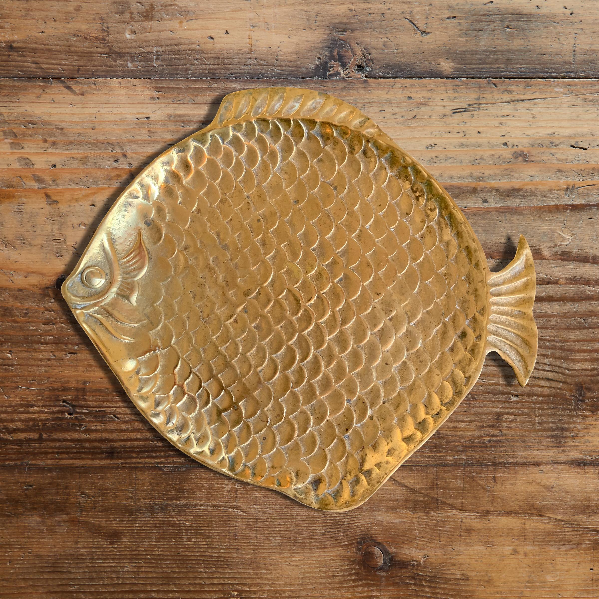 A wonderfully whimsical vintage English brass dish in the shape of a large fish with raised scales, and a charming facial expression. Perfect for catching your keys, pocket change, or your wallet.