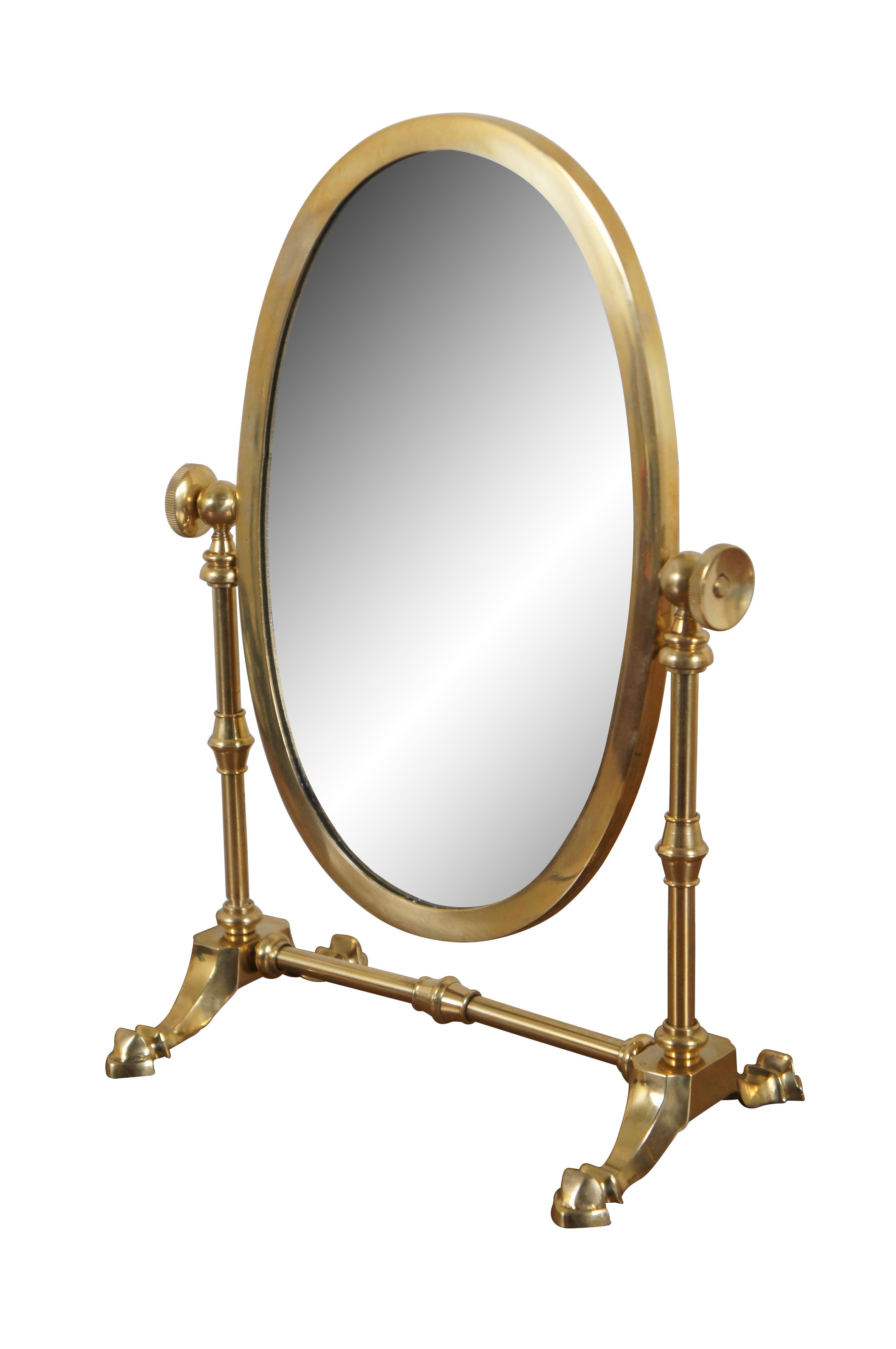 Mid to late 20th century tabletop vanity / shaving mirror featuring an oval mirror, adjustable tilt, and bright brass frame with trestle base.

Dimensions:

9