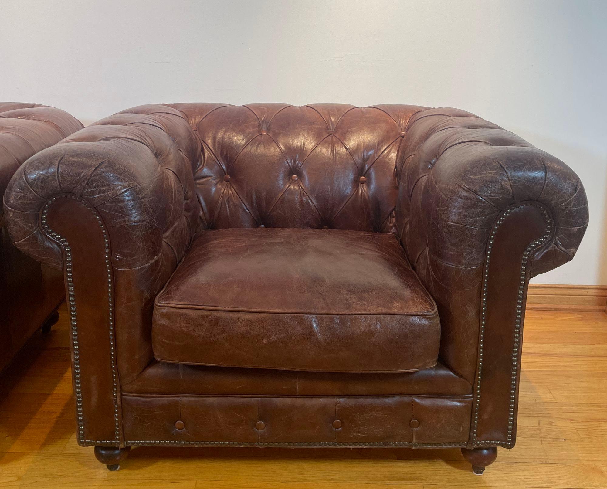Vintage English Brown Leather tufted Chesterfield Club Armchairs, England circa.
Pair vintage brown english traditional leather chesterfield club arm chairs.
Upholstered in tight button-tufted rich brown leather with nailhead trim, rolled arms and