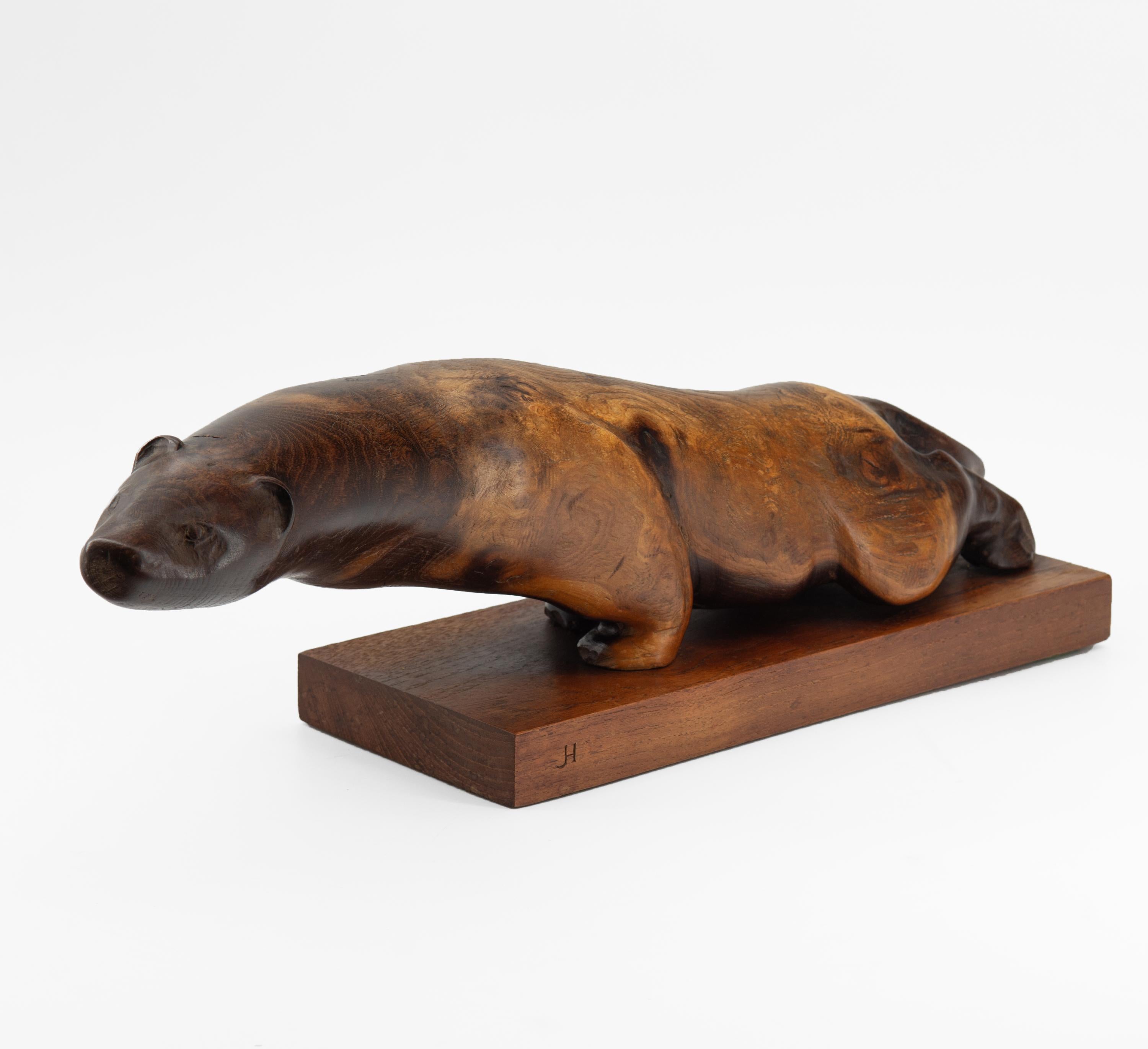 Vintage carved otter sculpture in burr elm on a solid teak plinth. Signed initials JH. English. Circa 1960.

Beautifully hand carved, note the wonderful graining and contrasting colour from head to tail.  In very good original condition, no damage.