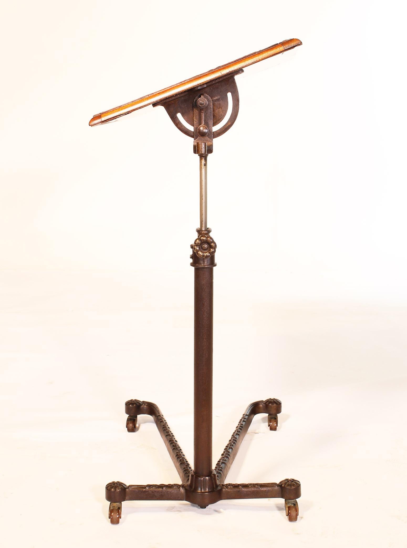 Original authentic mahogany and cast iron hospital bedside tilt-top table for serving. Made in London, England. Mahogany top has some cracks and other wear, is structurally sound. Cast iron decorative base in good condition. Measures: Height when