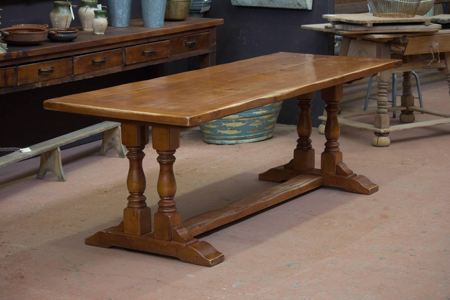 Vintage English cherrywood trestle table with single stretcher and two turned balusters to each end.