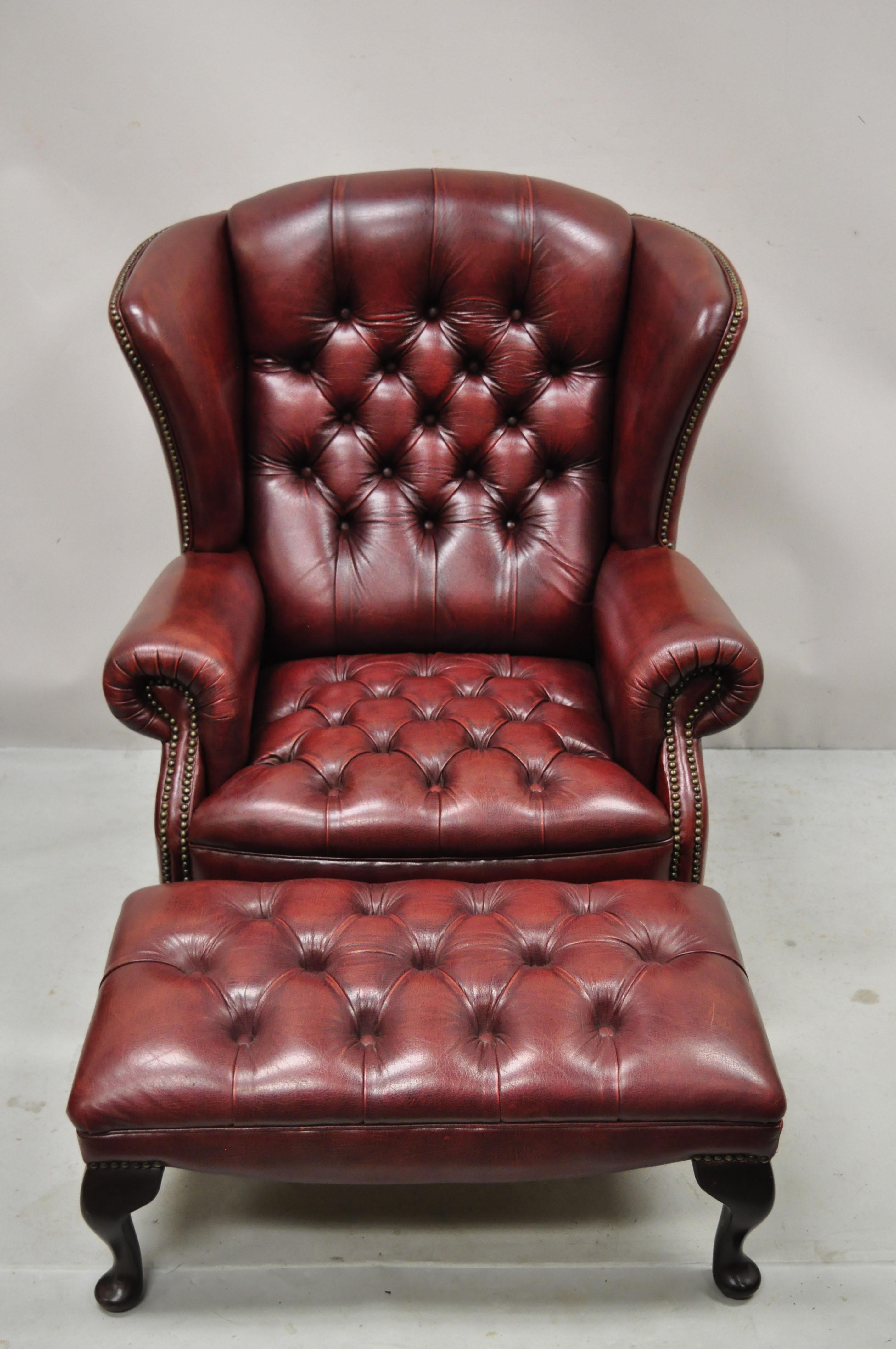 Vintage English Chesterfield Burgundy leather tufted wingback chair and ottoman by Action Furniture Ltd. Set includes chair and matching ottoman included, button tufted burgundy leather upholstery, Queen Anne legs, shapely wingback, original label,